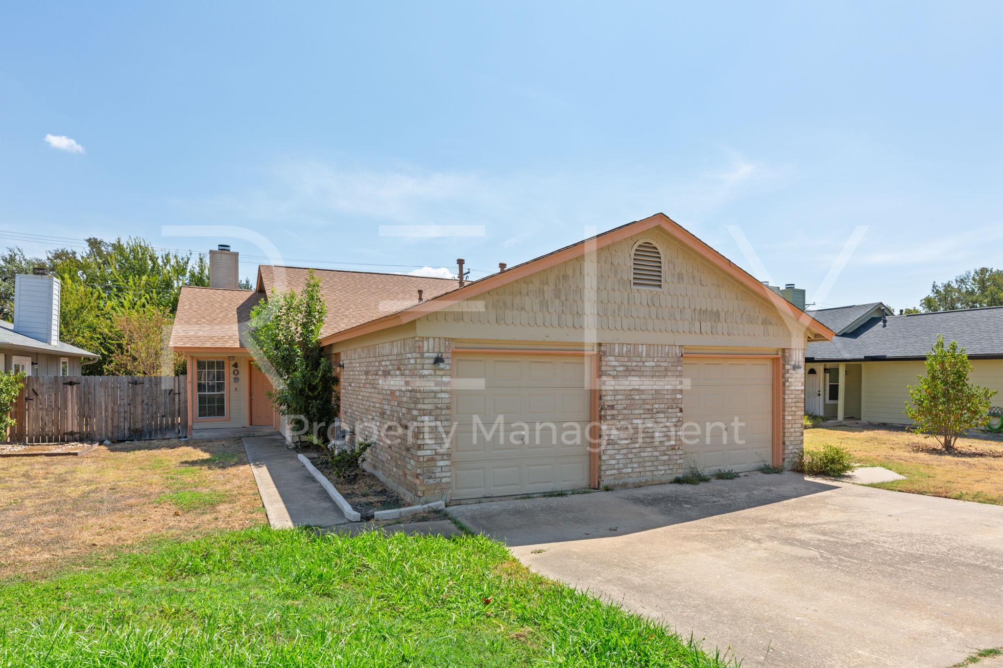 A spacious driveway leads to the two-car garage o