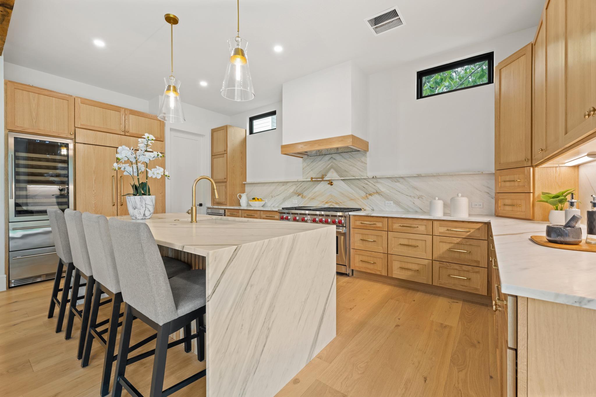 Warm wood cabinetry and bookmatched stone surface