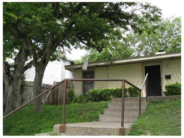 Concrete steps lead up to a classic brick exterio