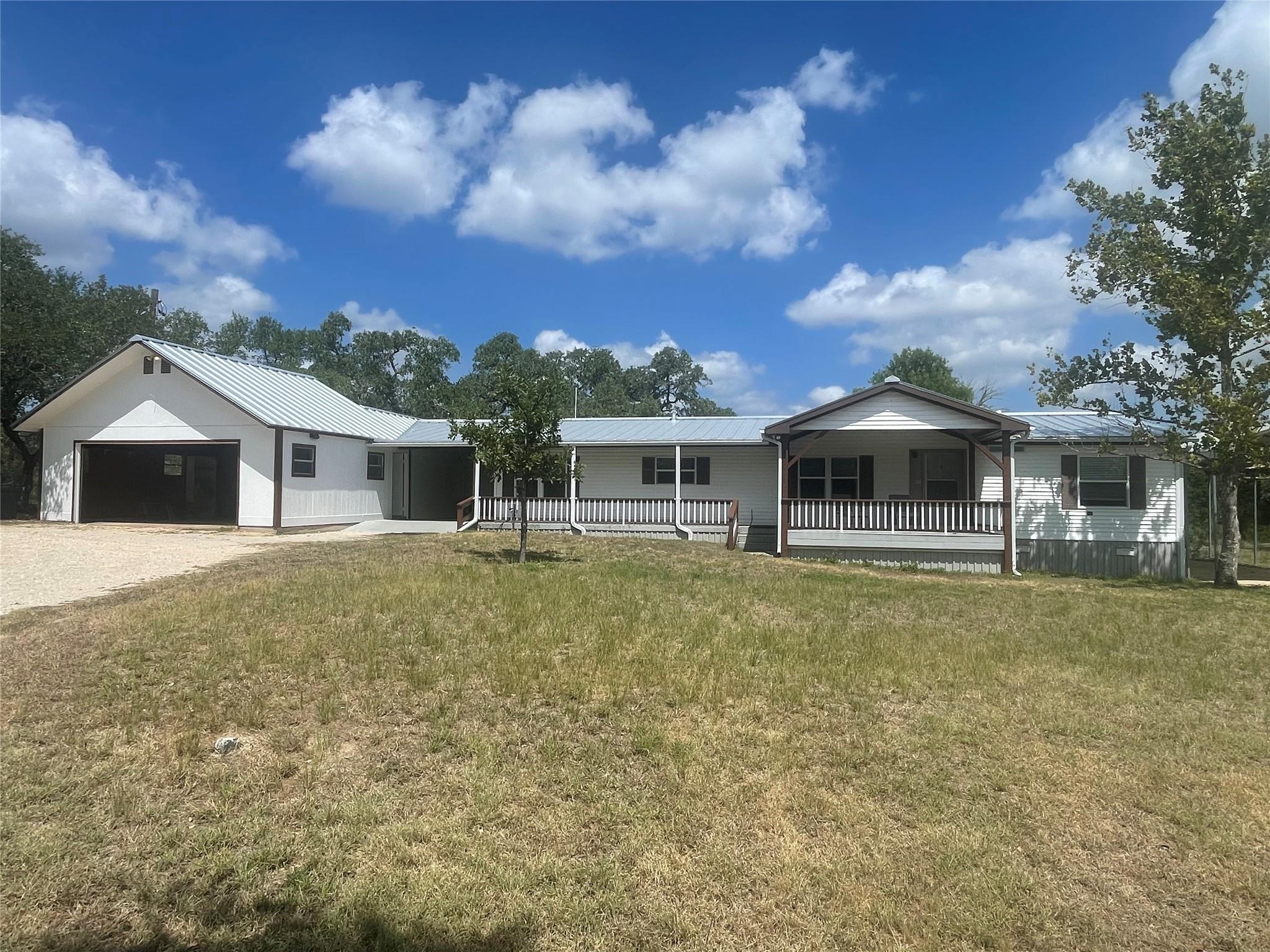 An expansive covered front porch runs along the f