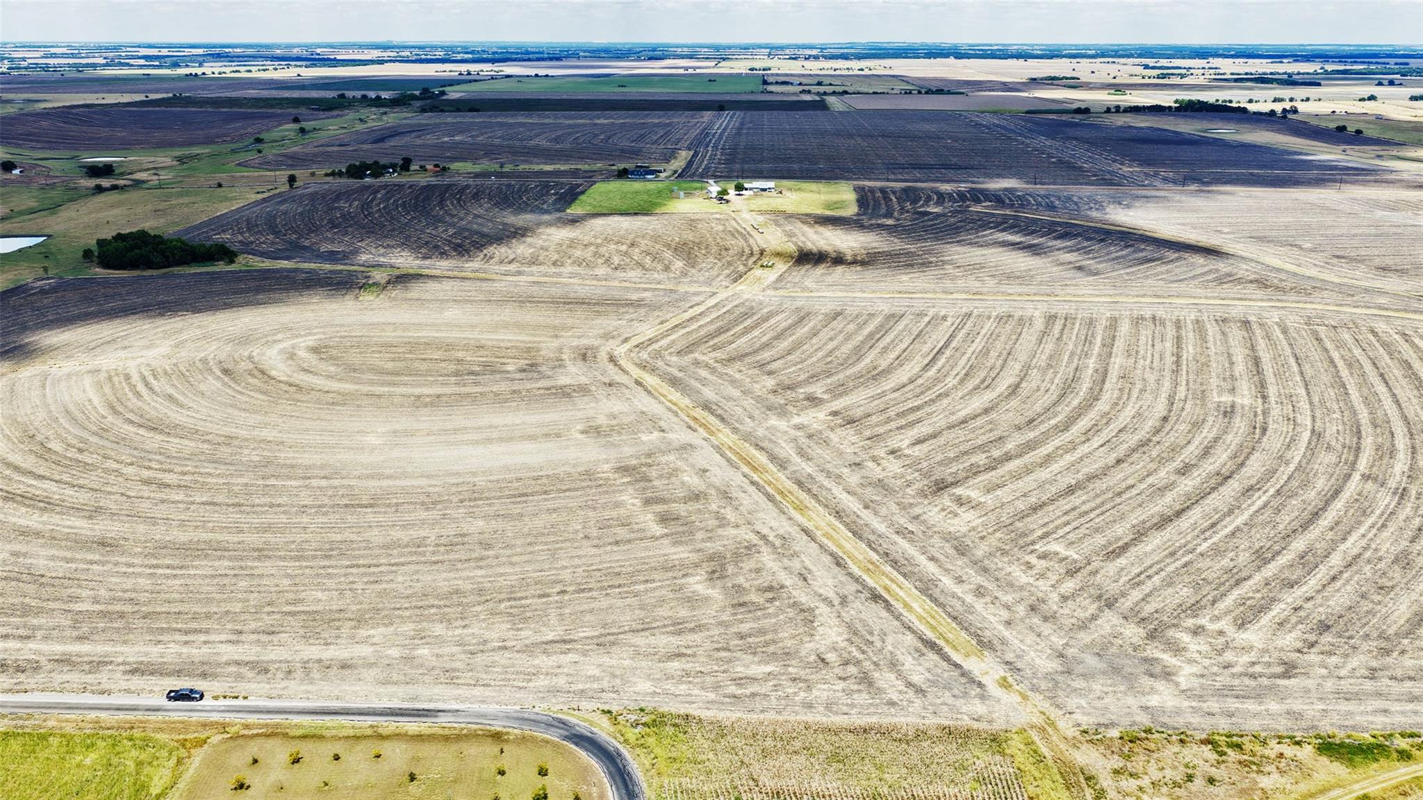 Vast sweeps of cultivated acreage unfold toward a