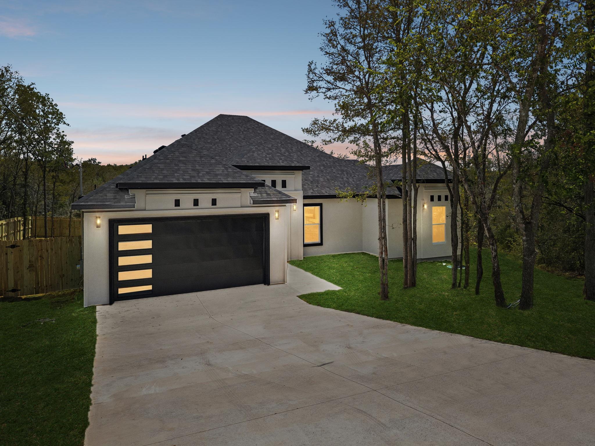 A spacious concrete driveway leads to a modern st