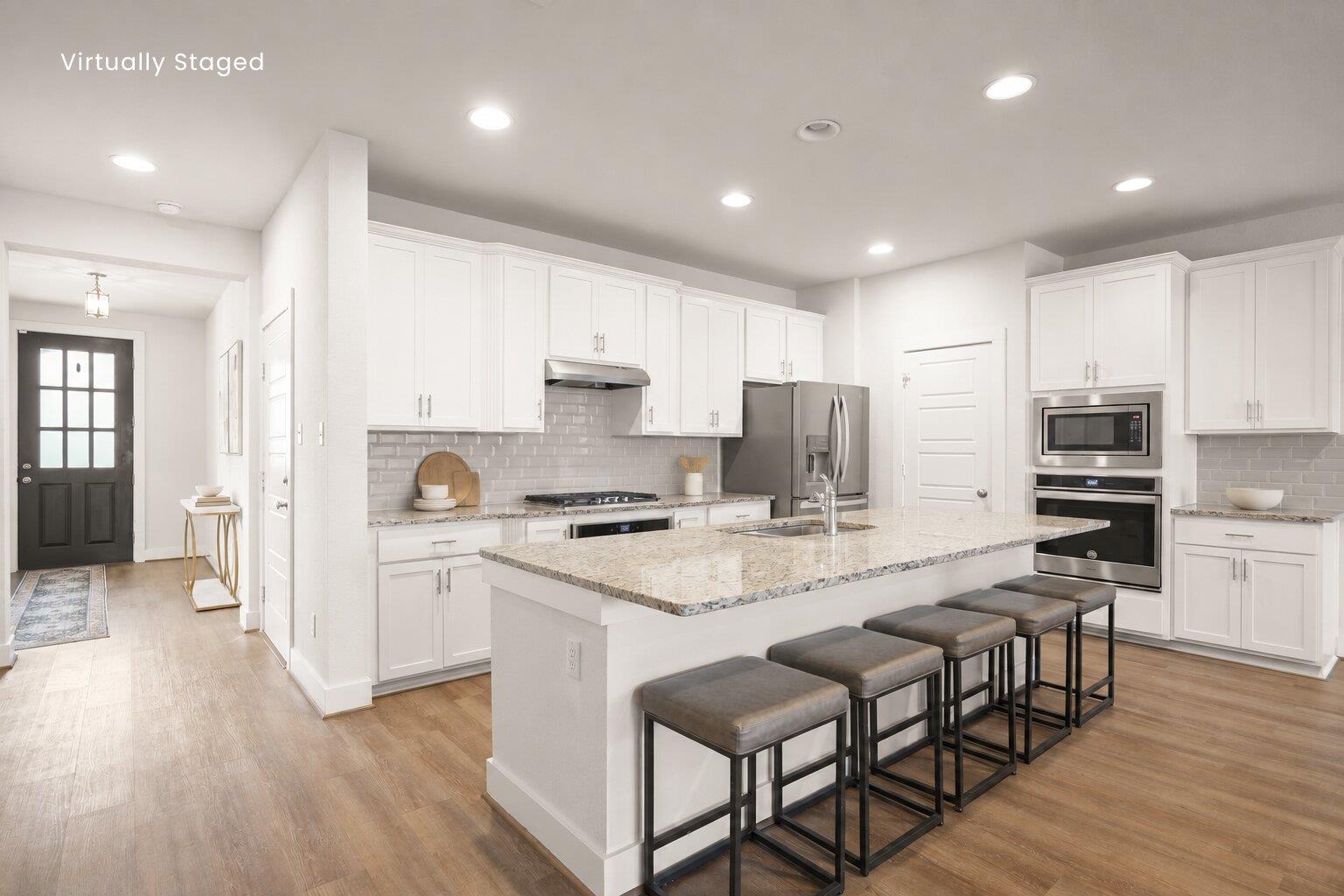 An open kitchen layout features a large stone isl