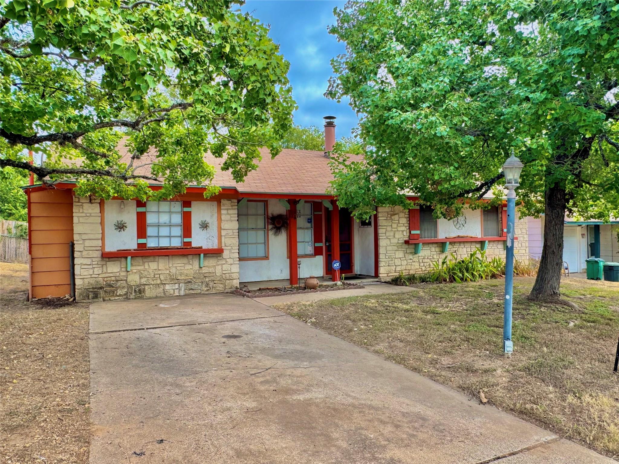 Mature trees frame this classic single-story home