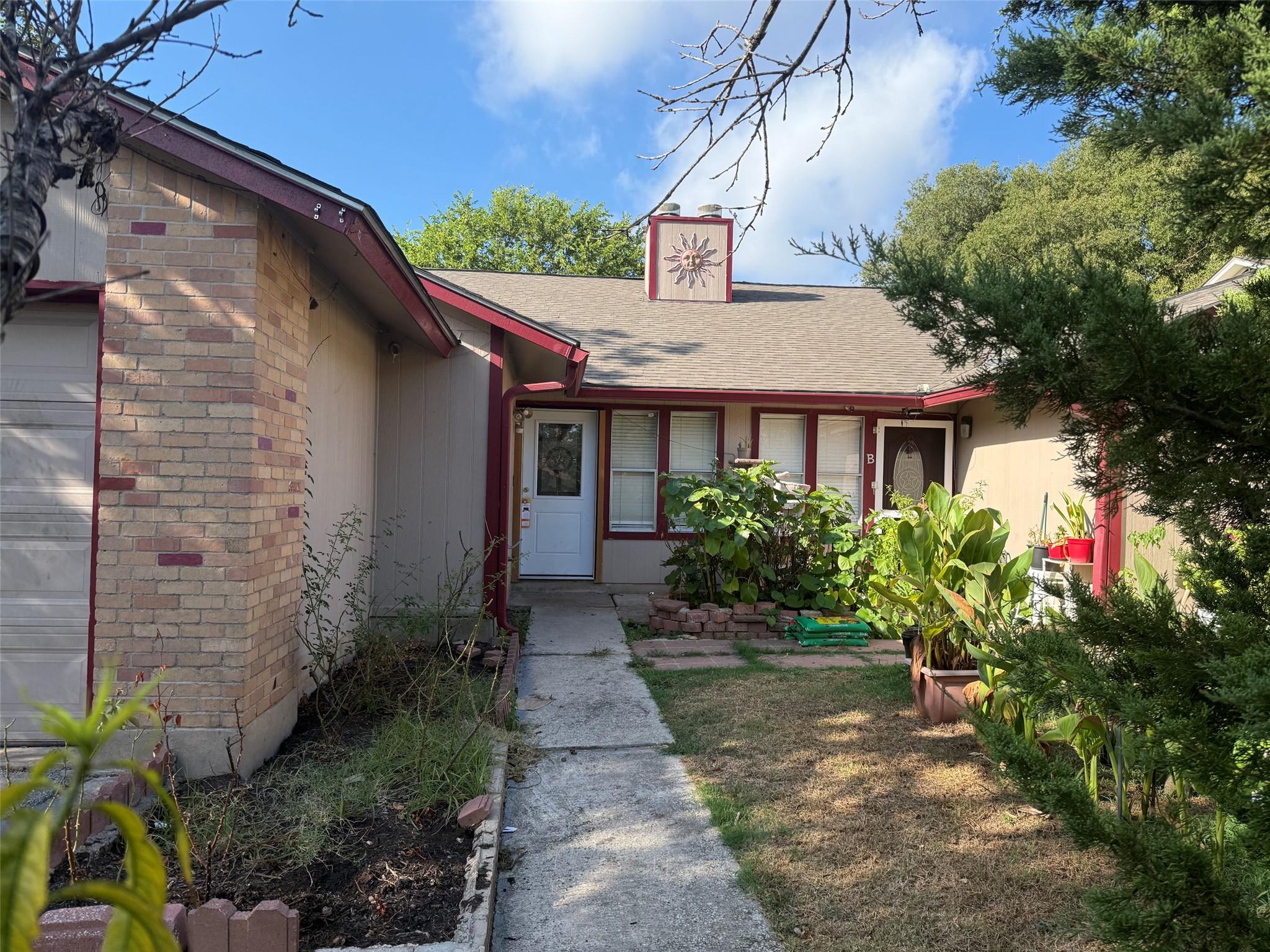 An inviting concrete walkway leads to the front e