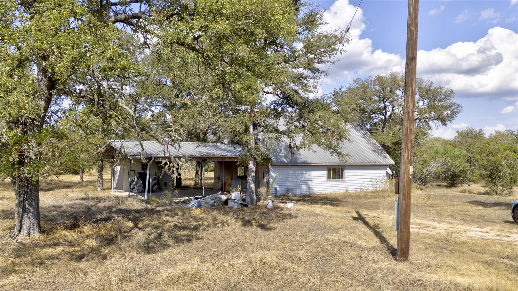 Mature trees shade a rural property featuring a m
