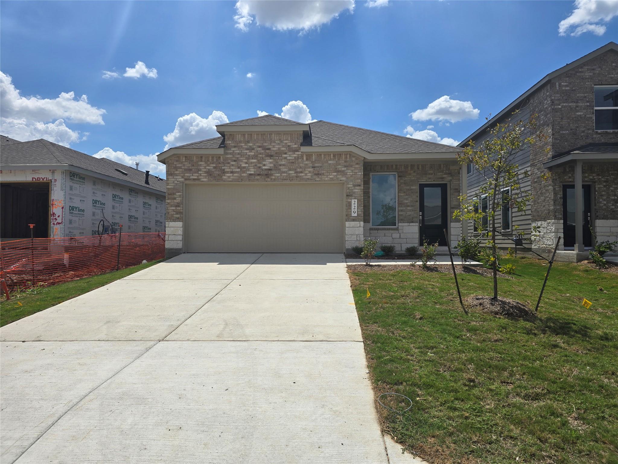 Classic brick accents and a spacious concrete dri