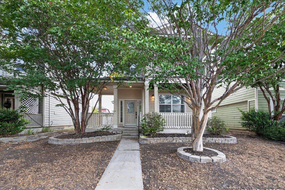 Mature trees frame a welcoming front porch and co