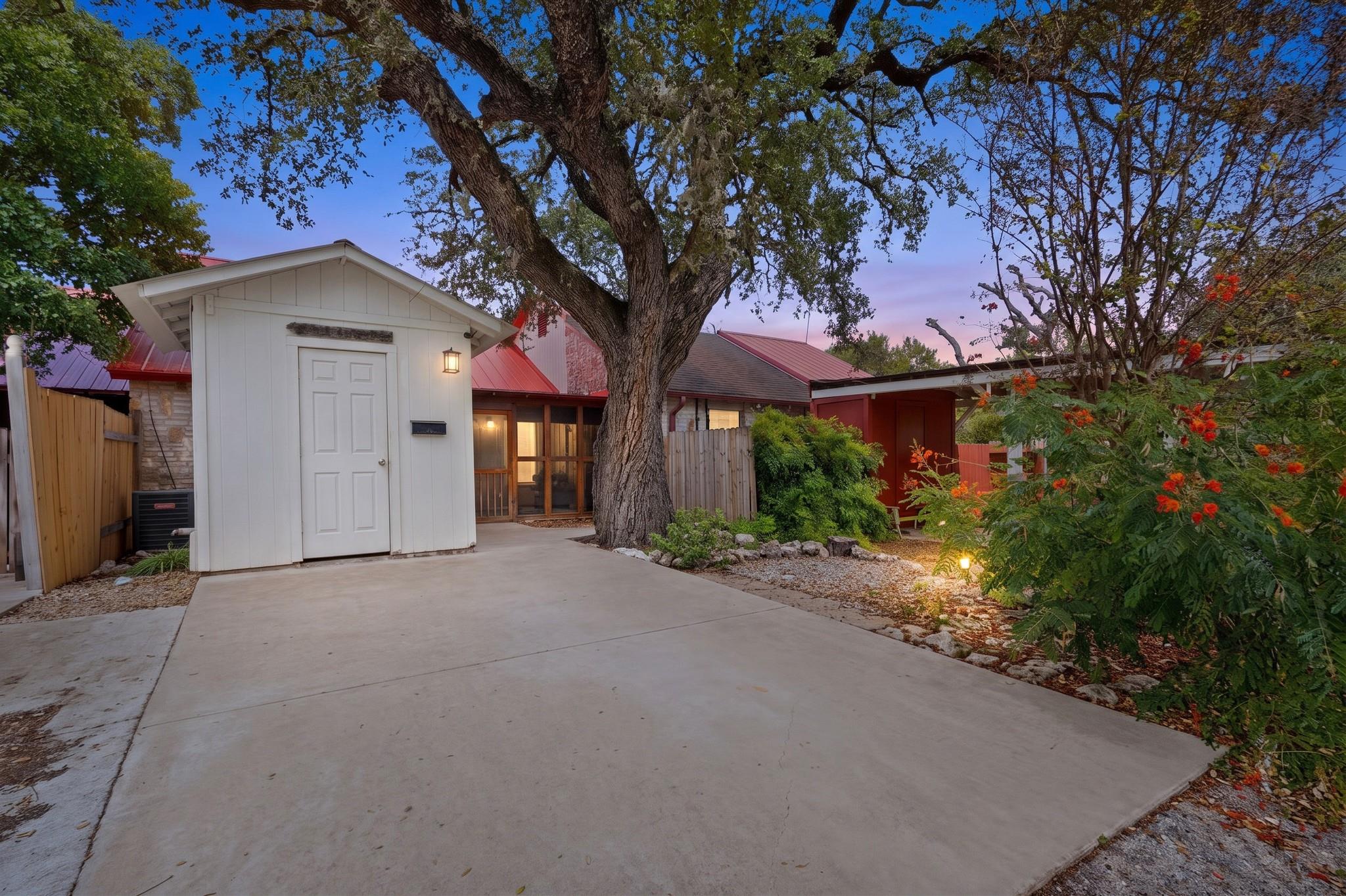 Mature trees shade a concrete driveway and detach