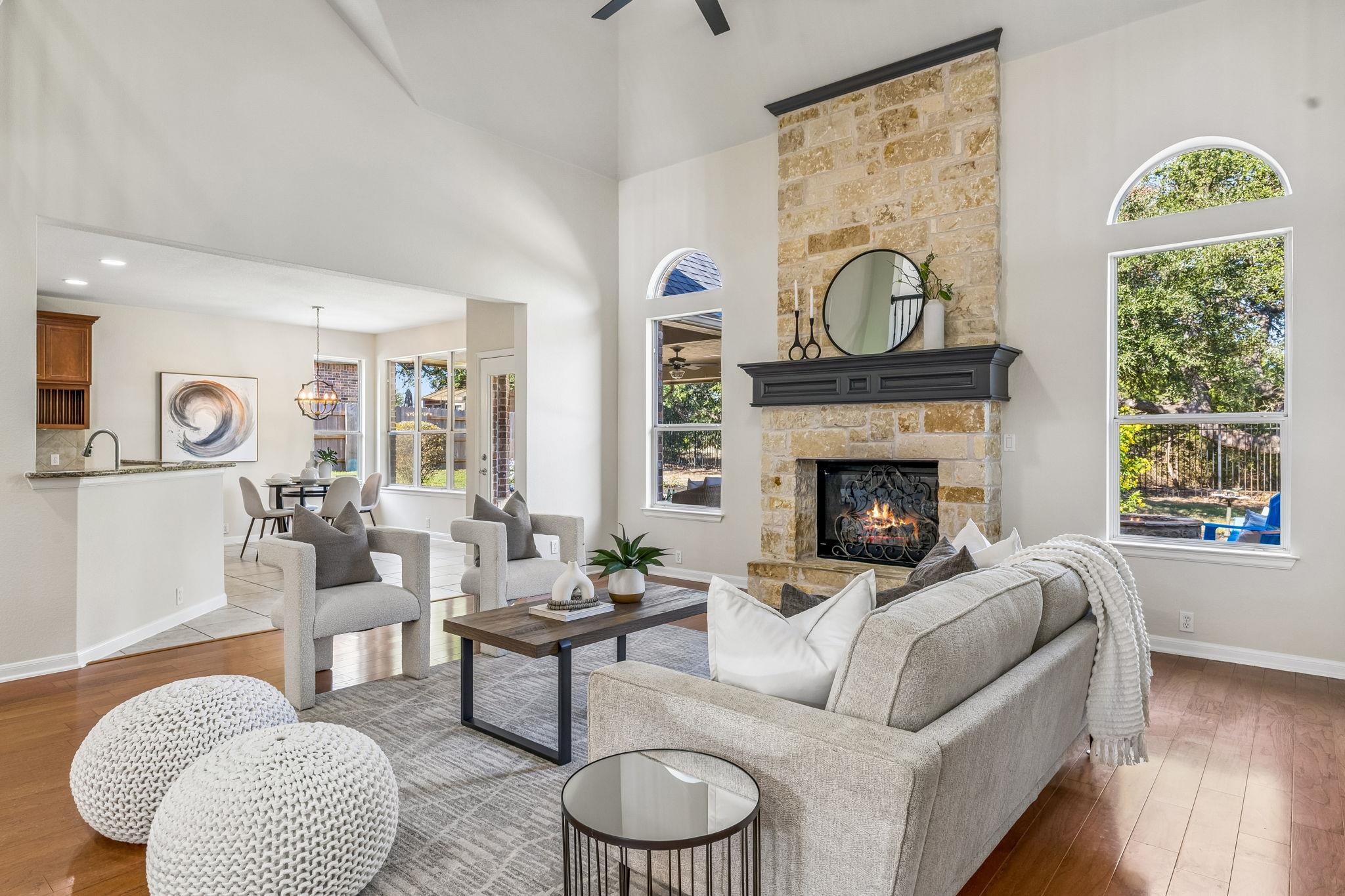 An imposing stone fireplace rises to meet soaring