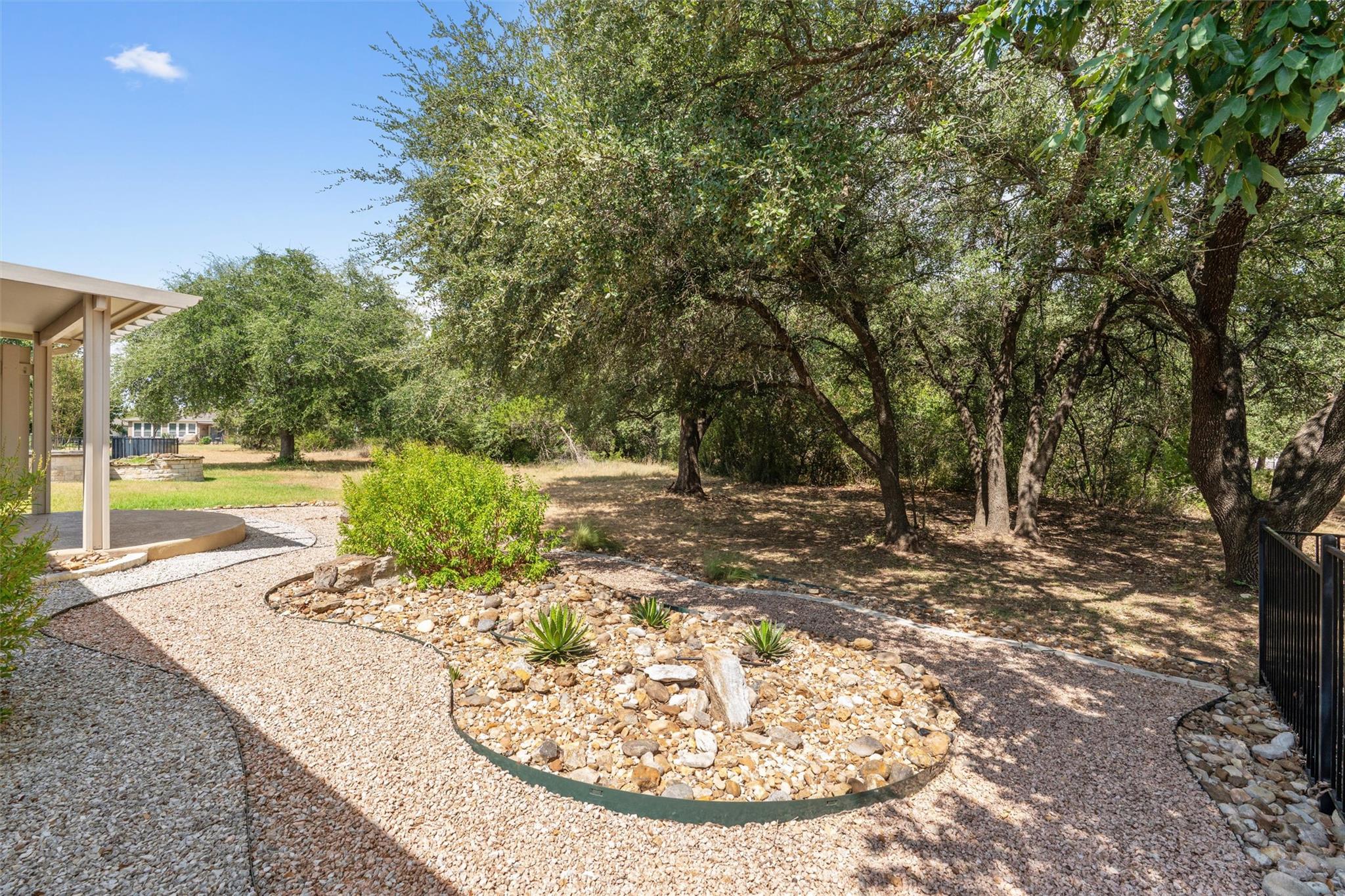 Mature trees shade a landscaped backyard featurin