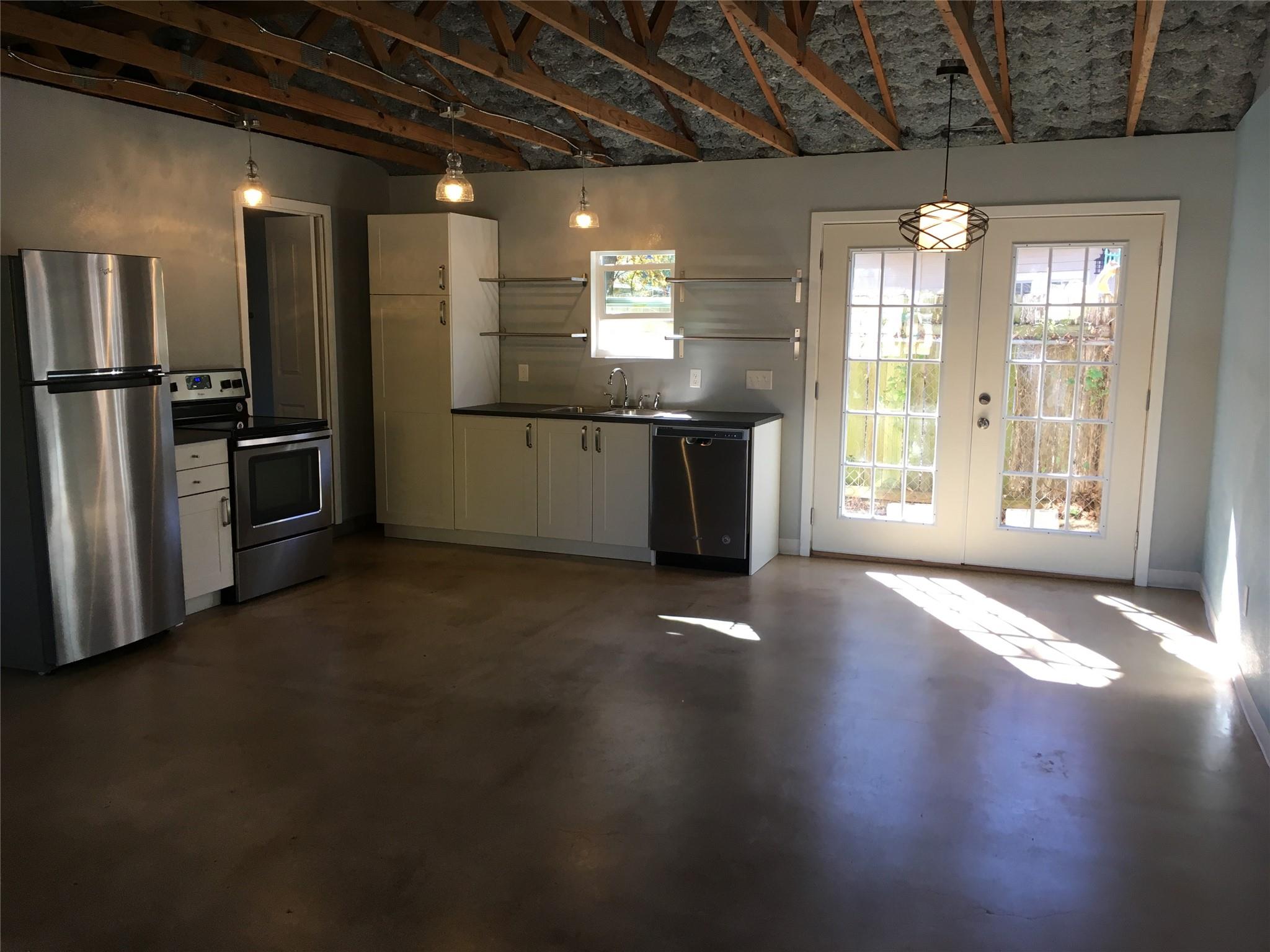 Exposed ceiling joists and smooth concrete floori