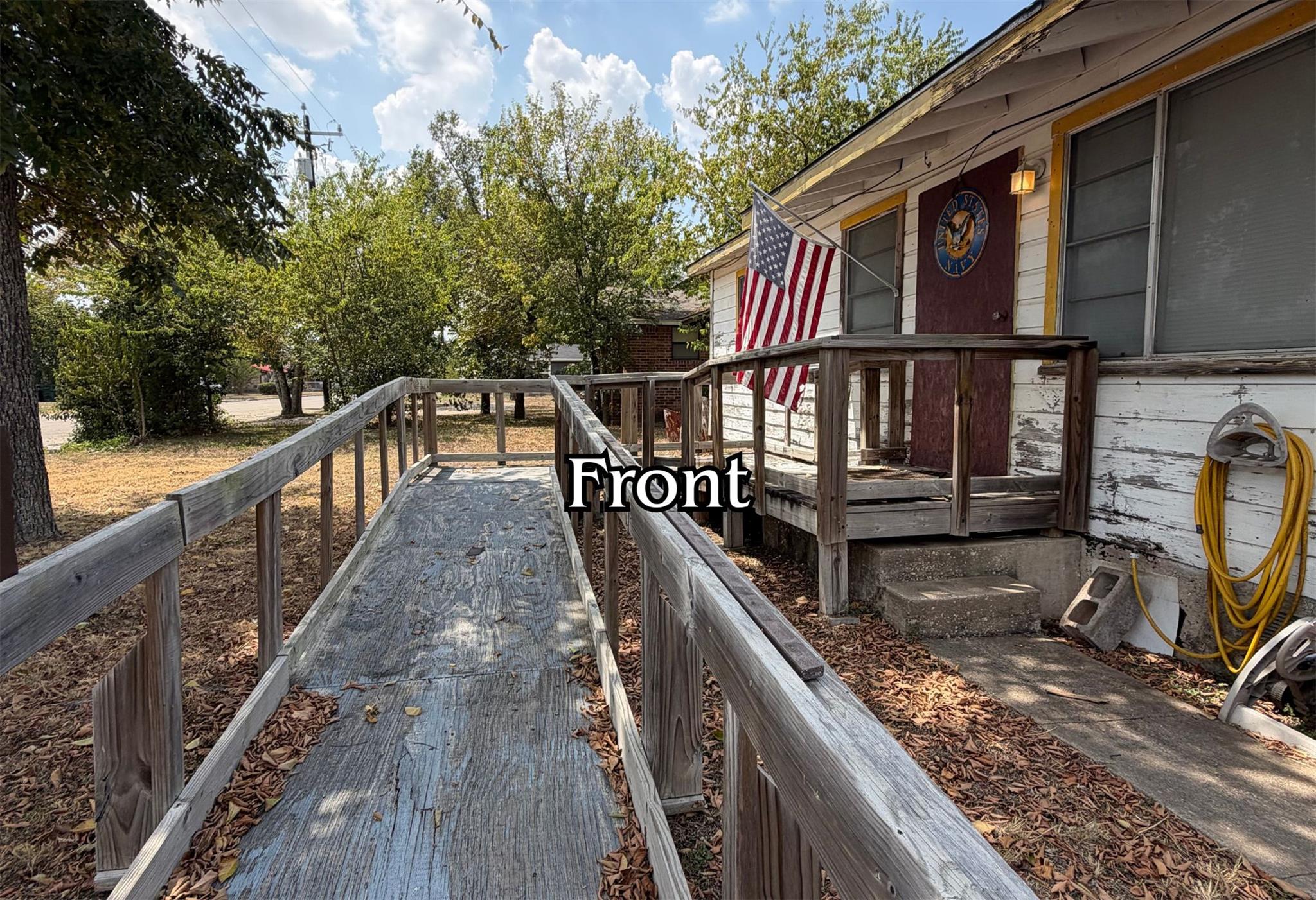 An integrated wooden access ramp leads to the fro