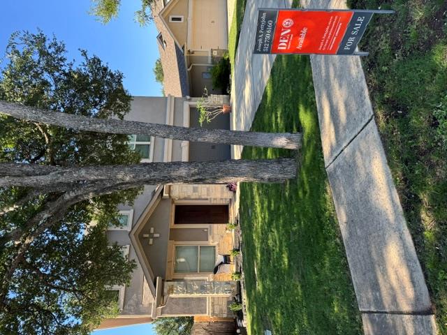 A welcoming stone facade and mature trees enhance