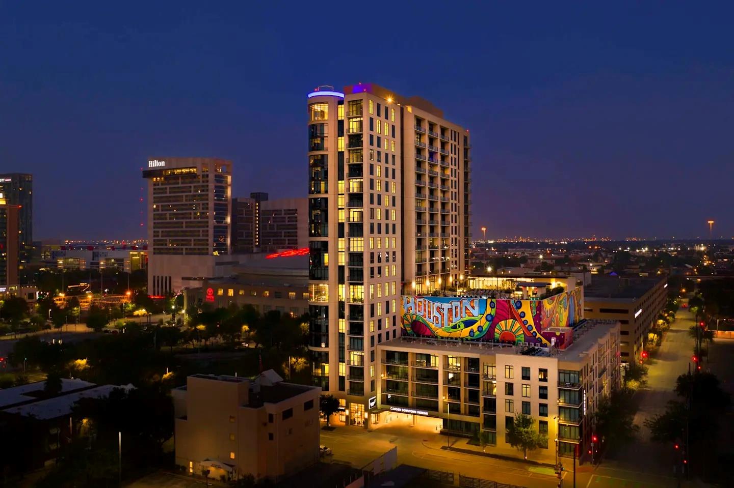 An illuminated high-rise building stands prominen