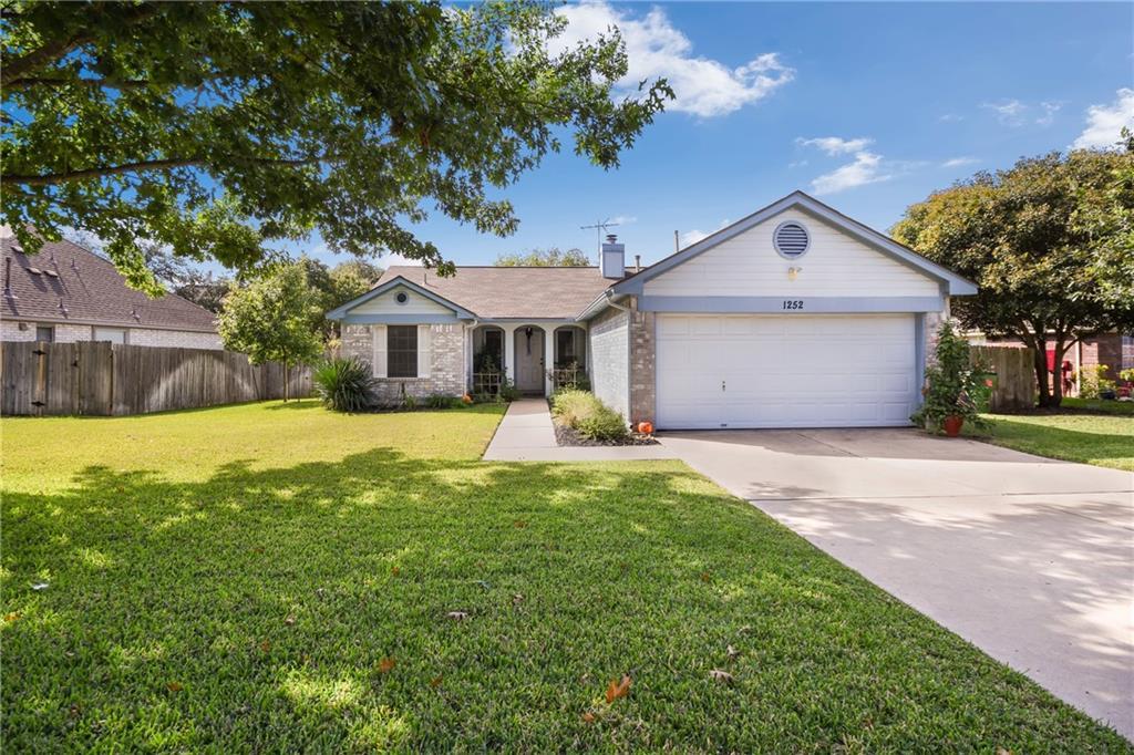 Mature trees shade a welcoming front lawn leading