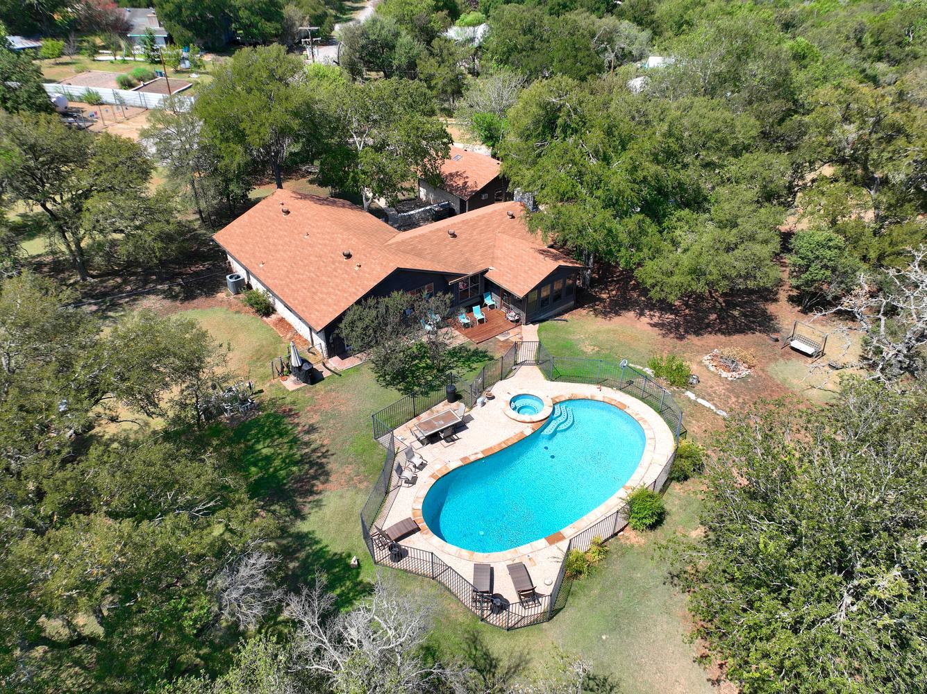 Mature trees surround a private pool and spa on t