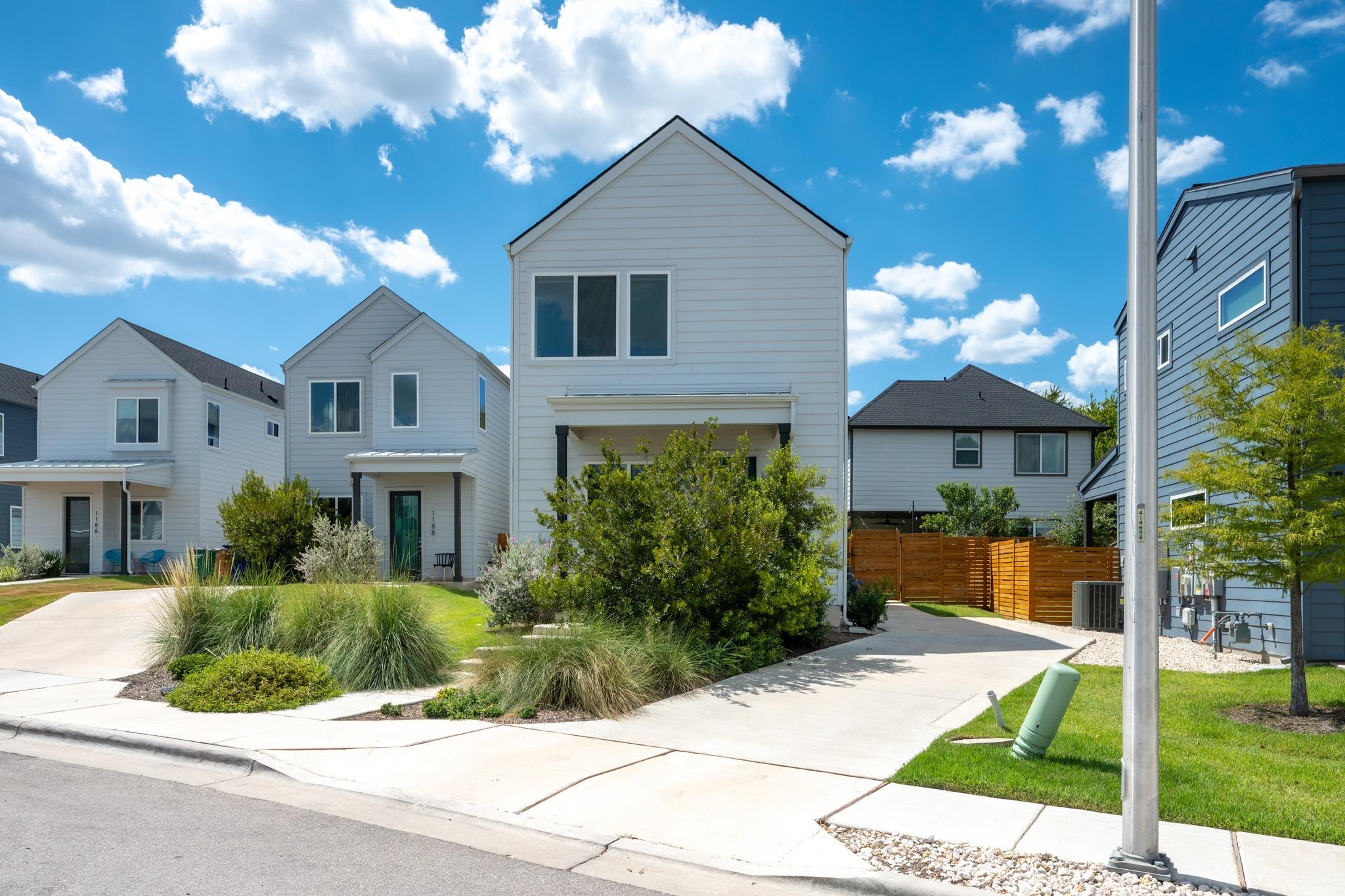 A crisp concrete driveway leads toward this moder