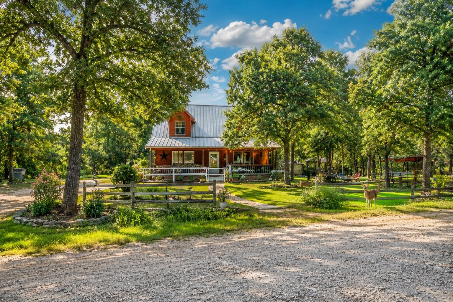 Mature trees frame a charming metal-roofed countr