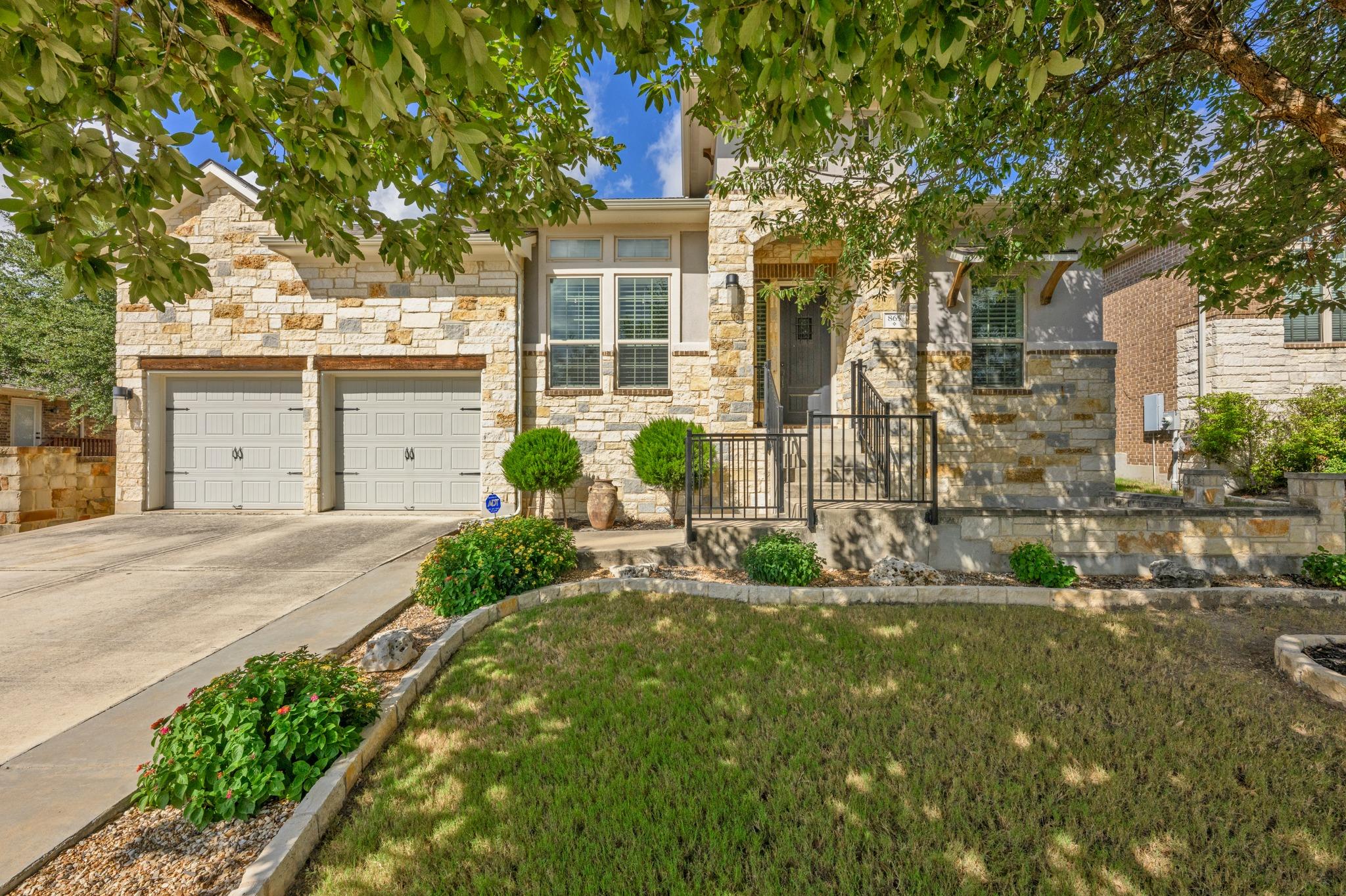 Natural stone masonry and a concrete driveway lea