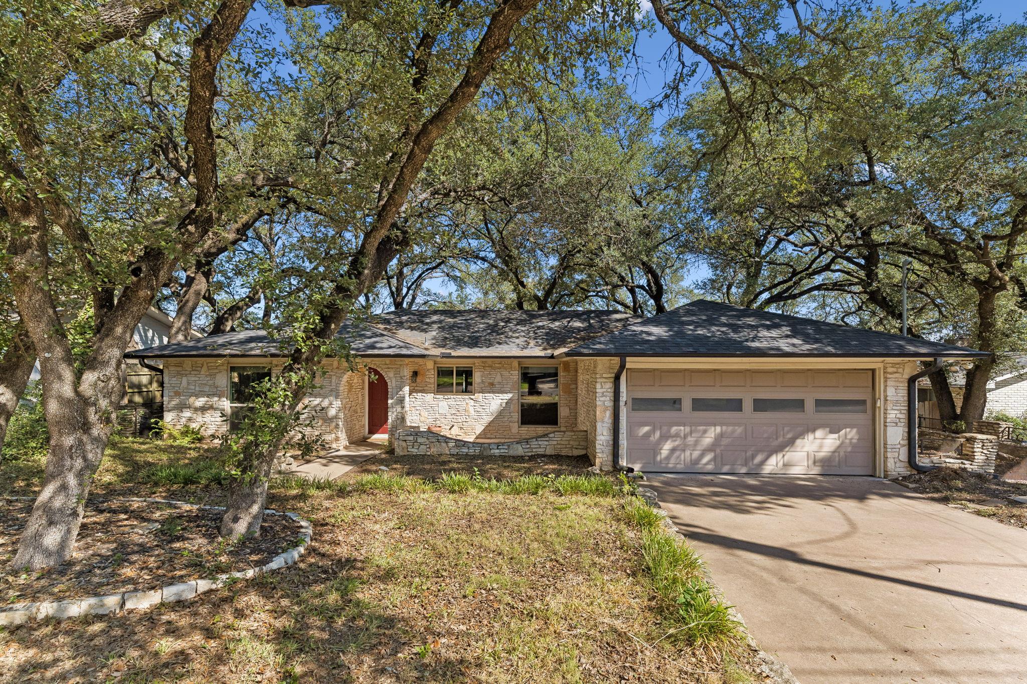 Mature trees shade a classic stone exterior with 