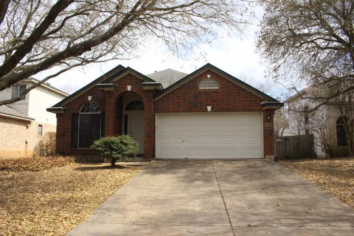 Mature trees frame a classic brick exterior with 
