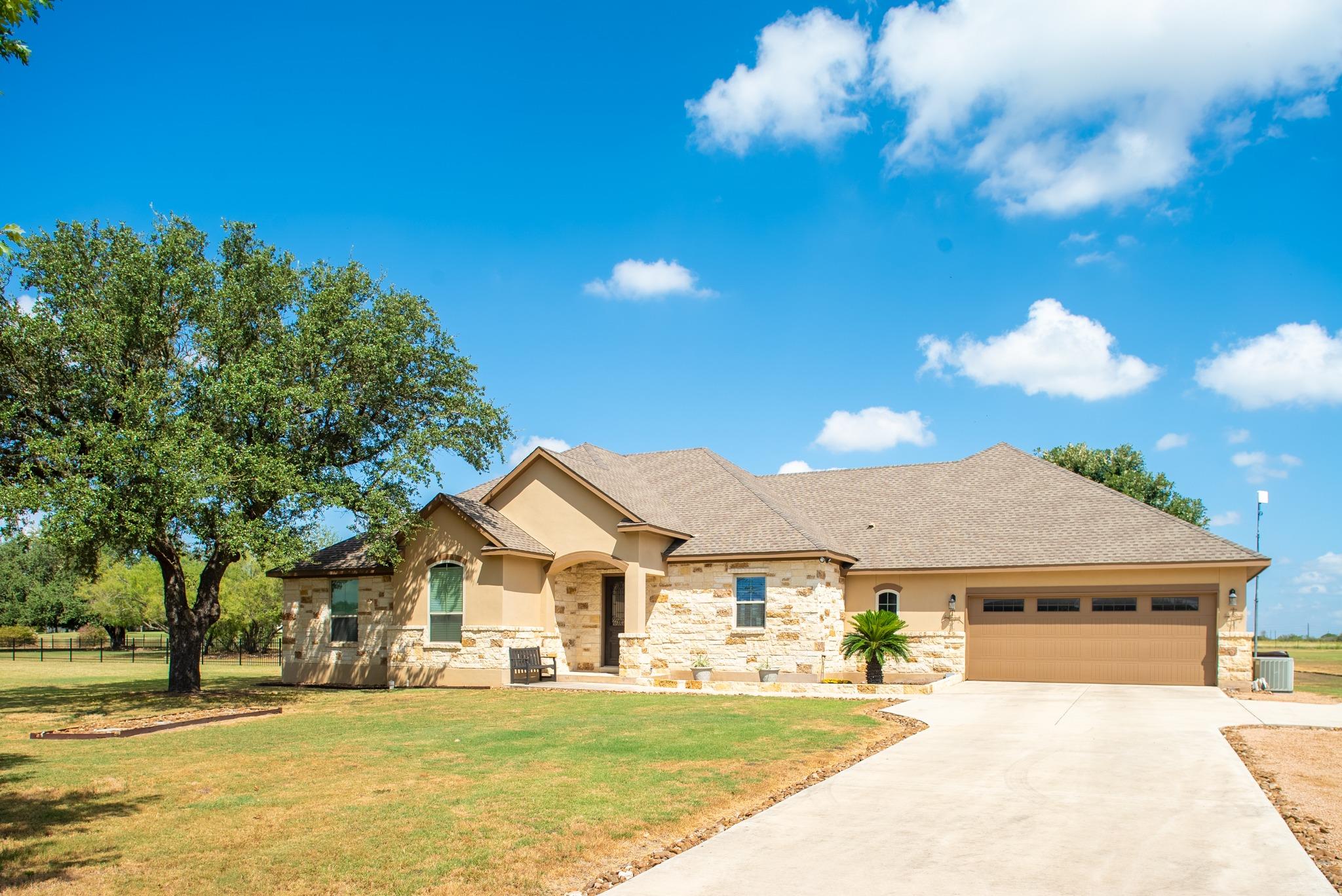 A spacious driveway leads to this stone-accented 