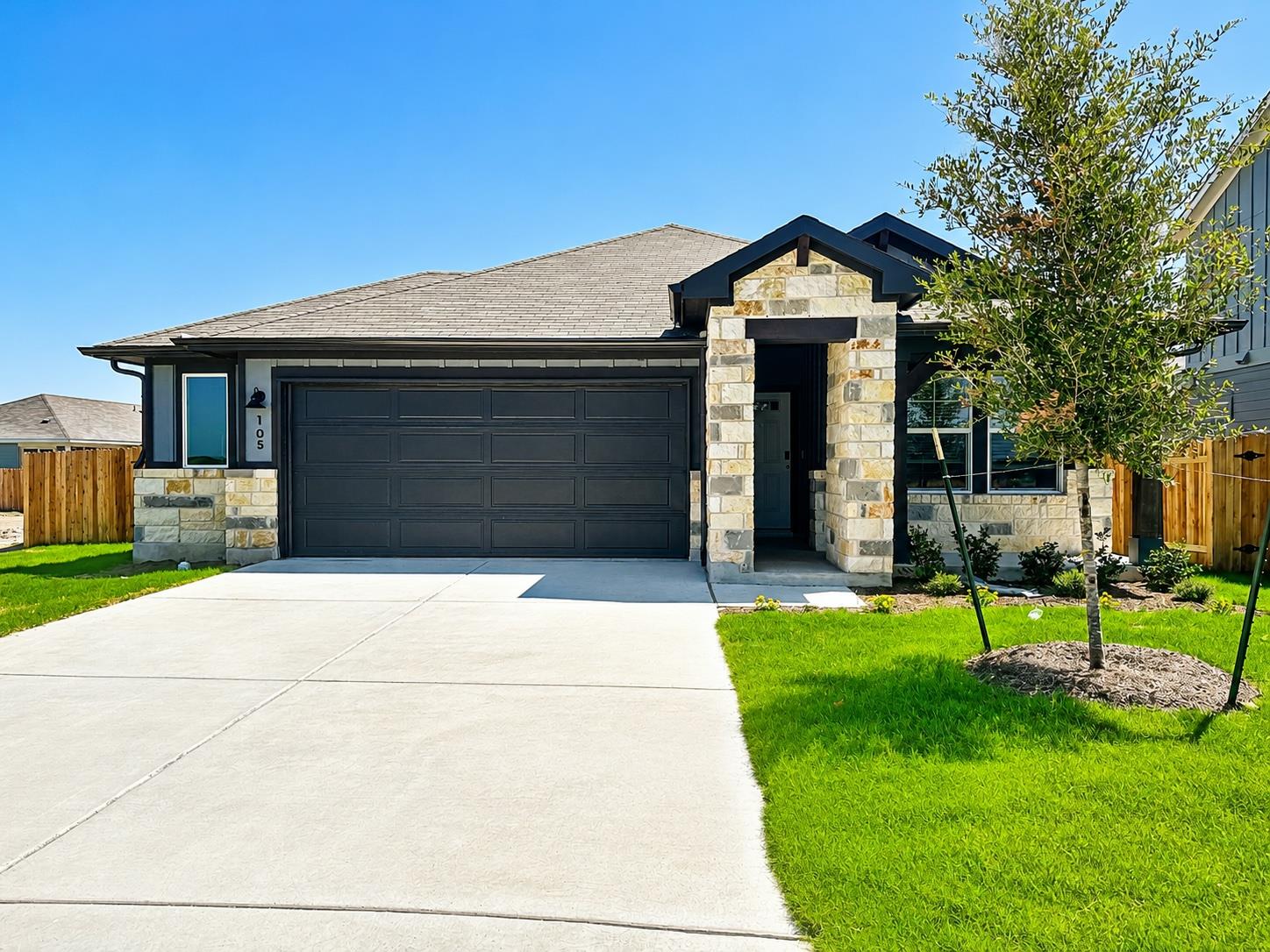 Natural stone accents and a manicured lawn create