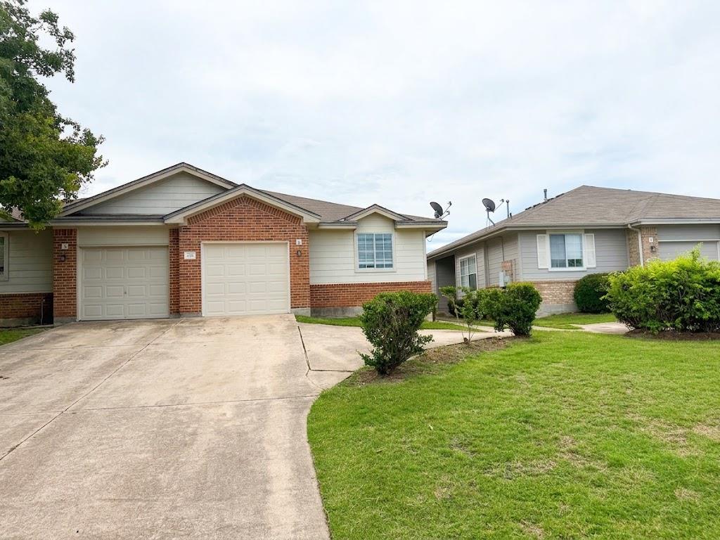 Classic brick accents and a concrete driveway def