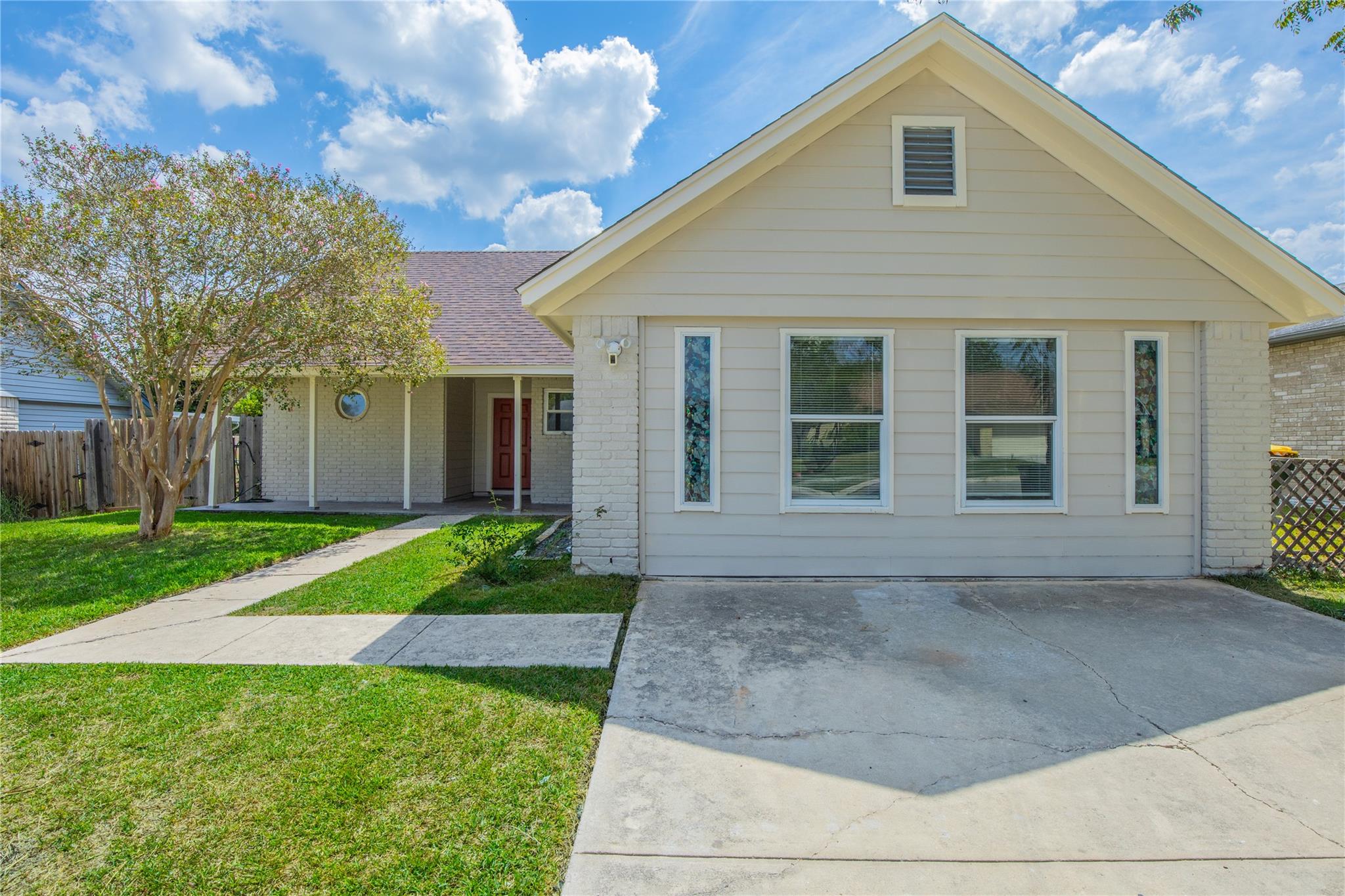 An inviting front facade features a neat lawn, co