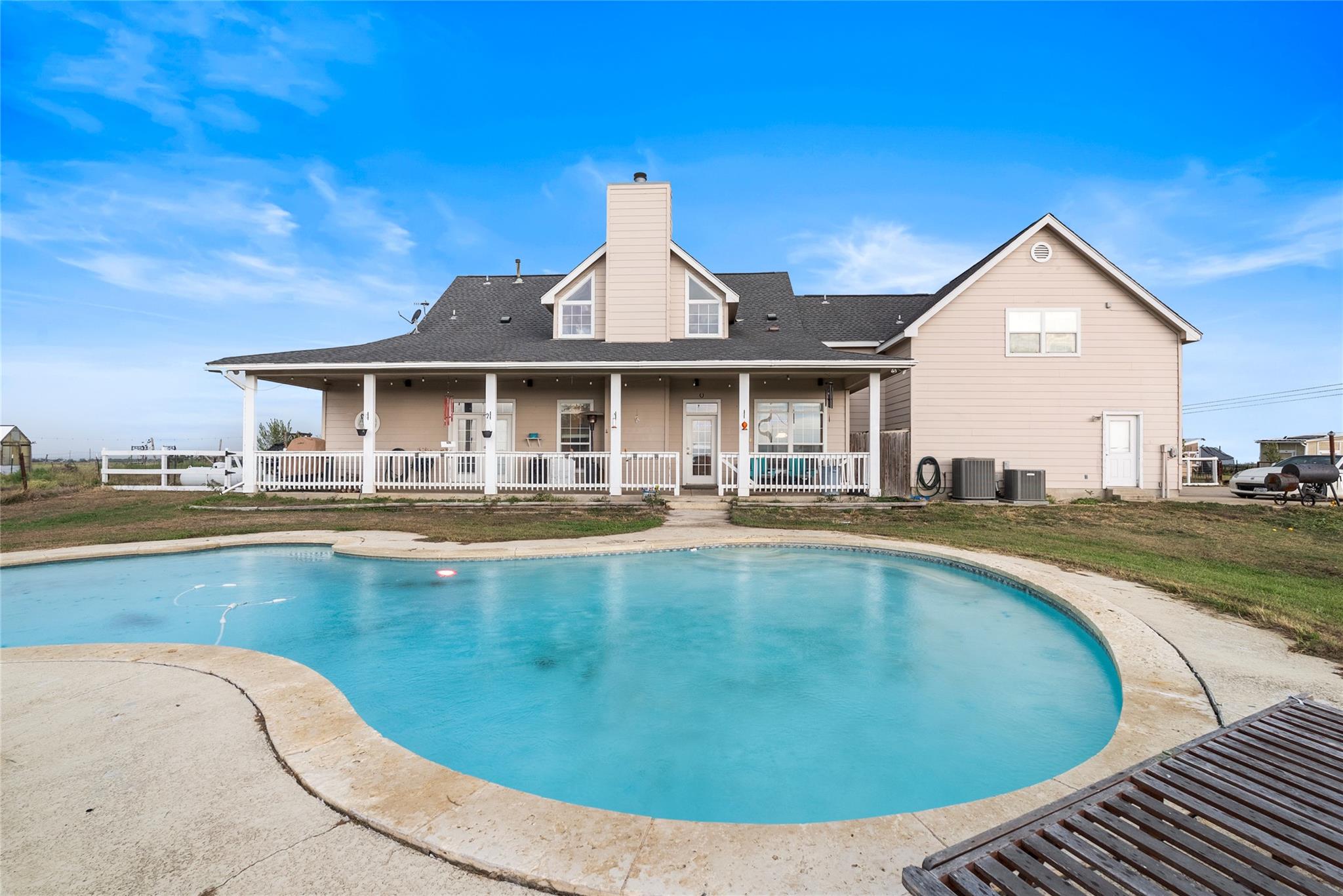 An inviting in-ground swimming pool anchors the s