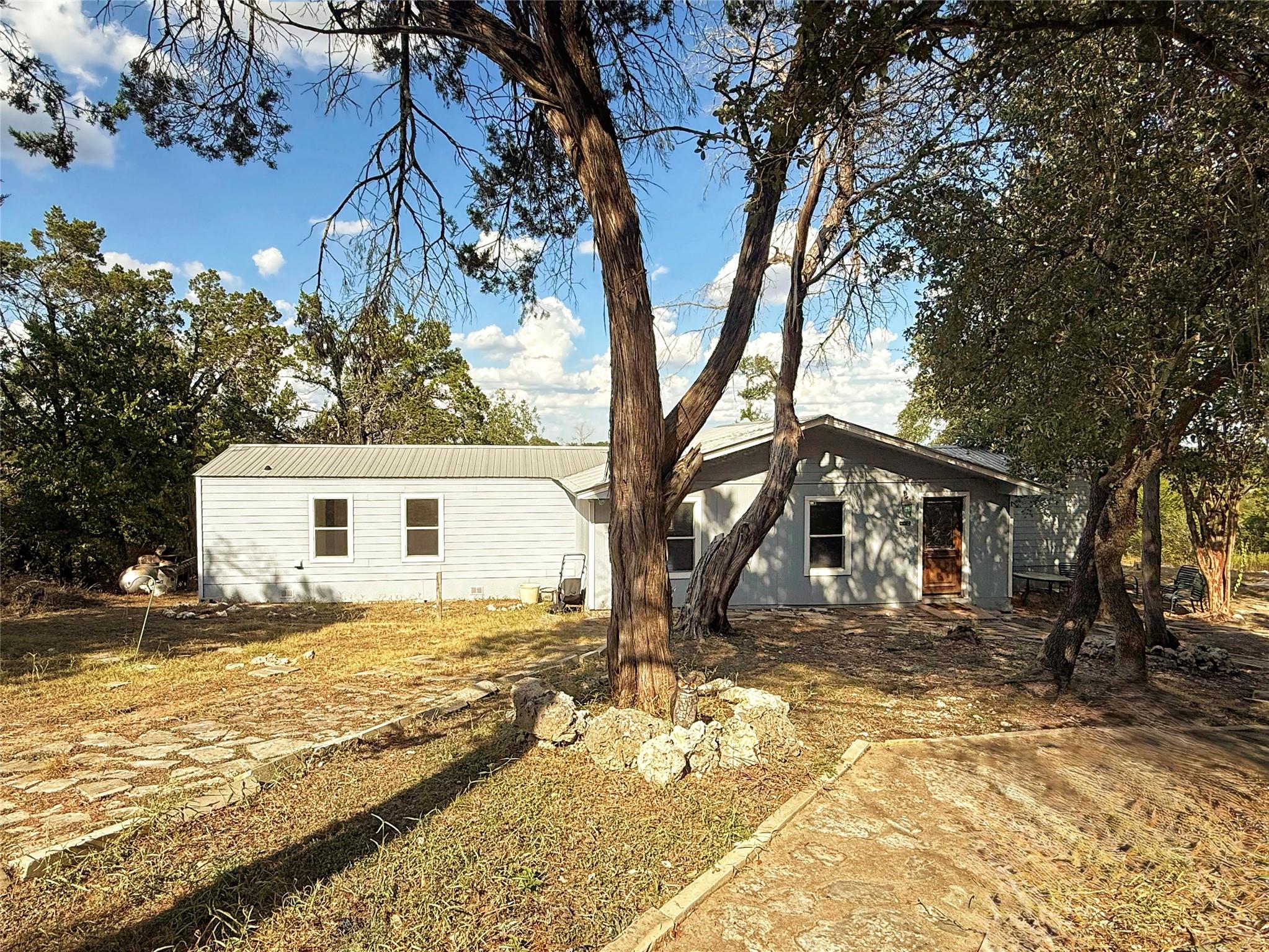 Mature trees shade a charming single-story home f