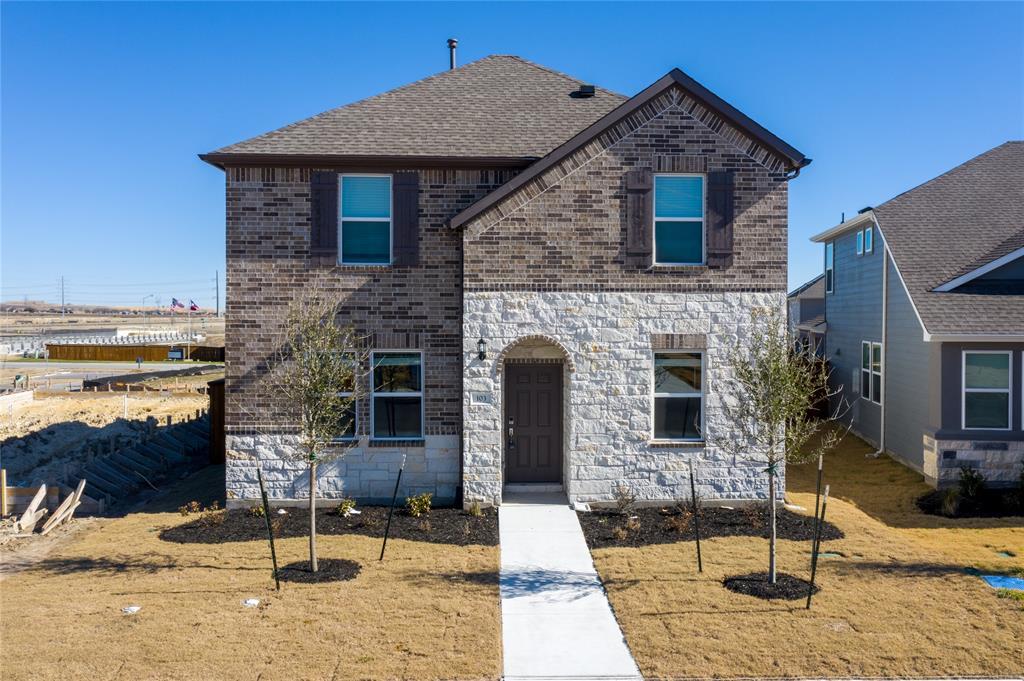 An arched stone entryway highlights the handsome 