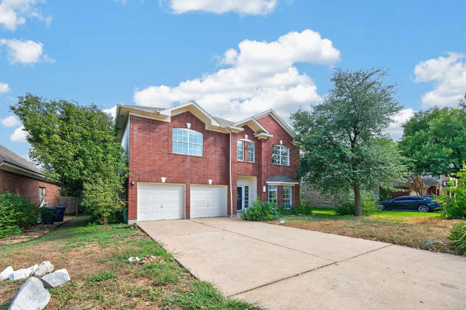 A spacious concrete driveway leads directly to th