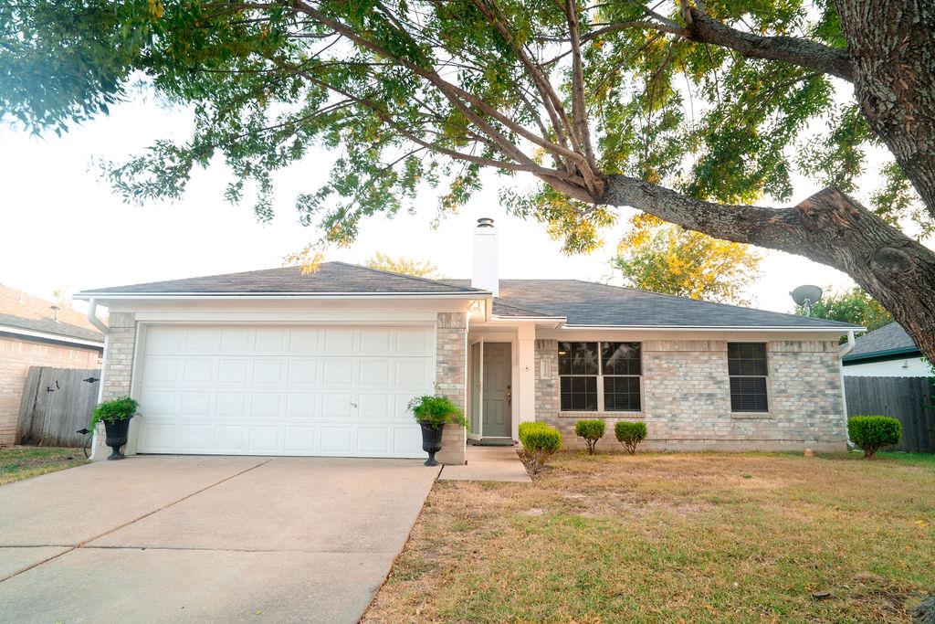 Mature trees frame the classic brick exterior and