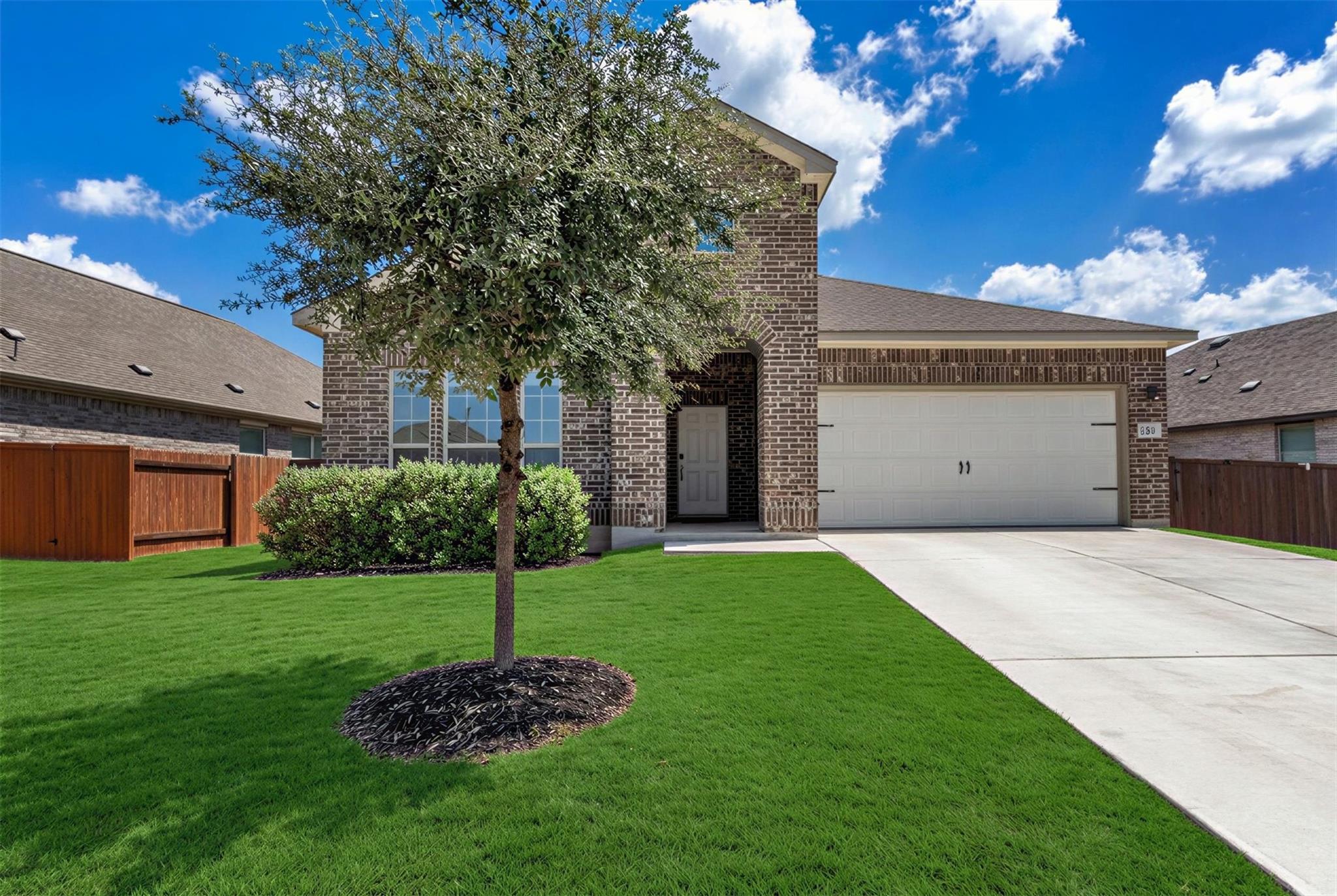 A classic brick exterior, neat concrete driveway,