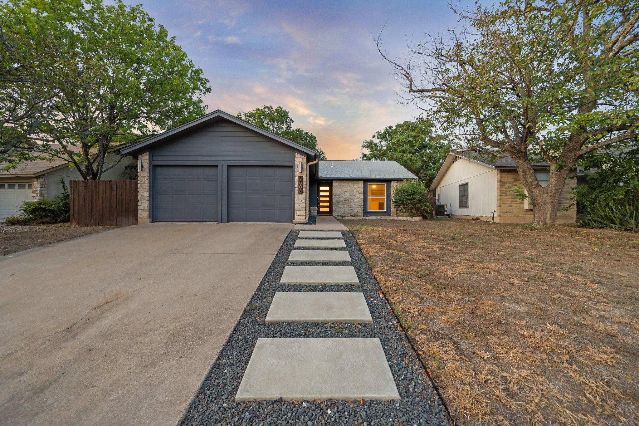 Geometric concrete pavers lead past a two-car gar