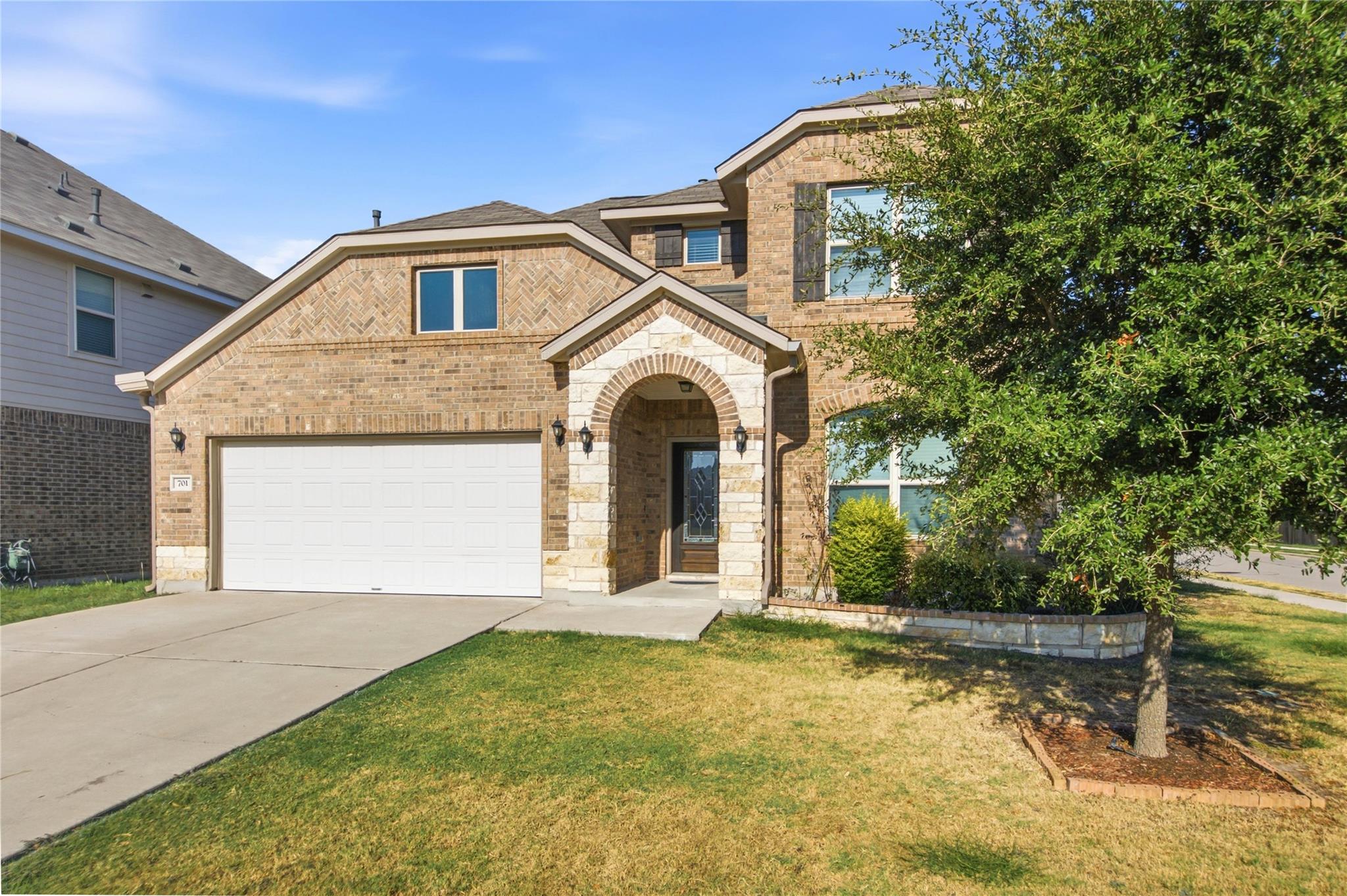 An arched stone entryway and mixed masonry accent