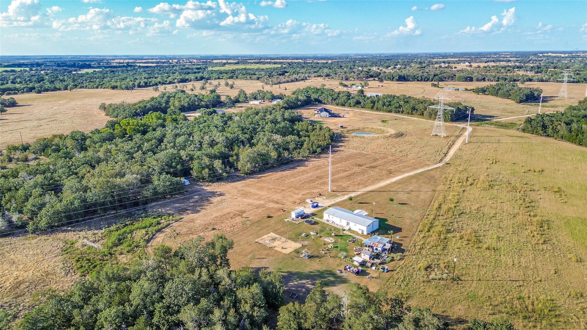 A vast expanse of rural acreage features a main h