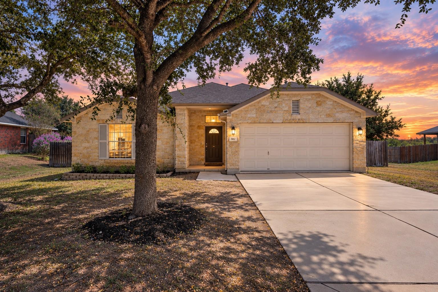 Mature trees frame a classic stone exterior front