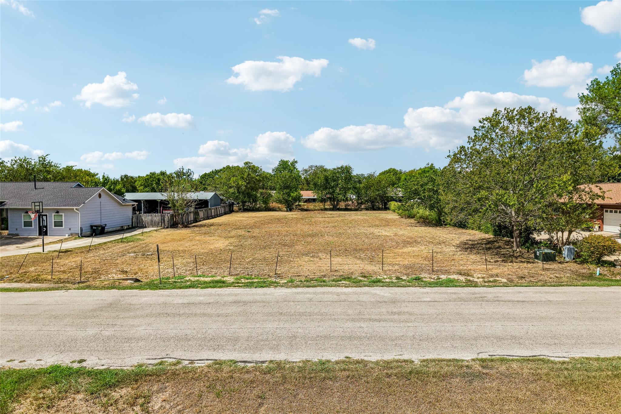 An open cleared parcel of land bordered by mature