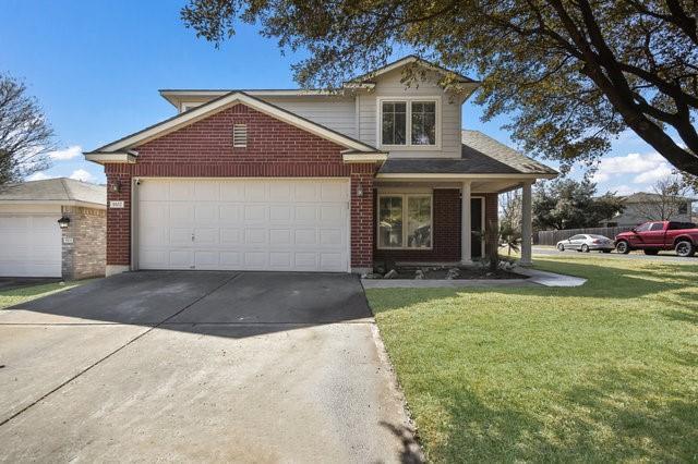 A classic brick-front residence with a two-car ga