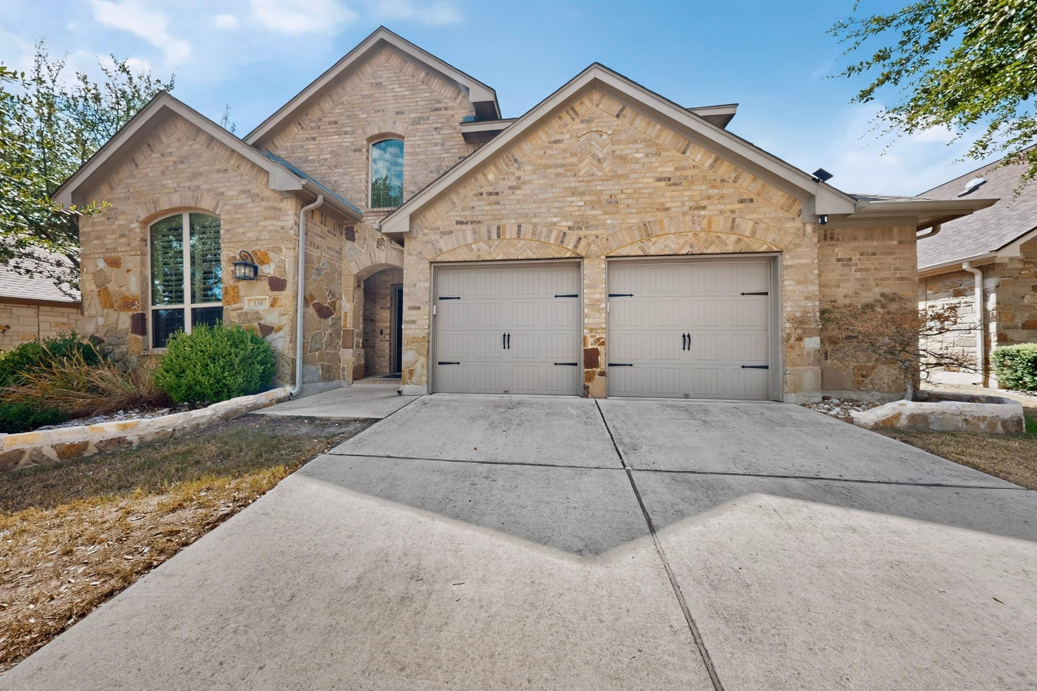 Textured brickwork and a wide concrete driveway d