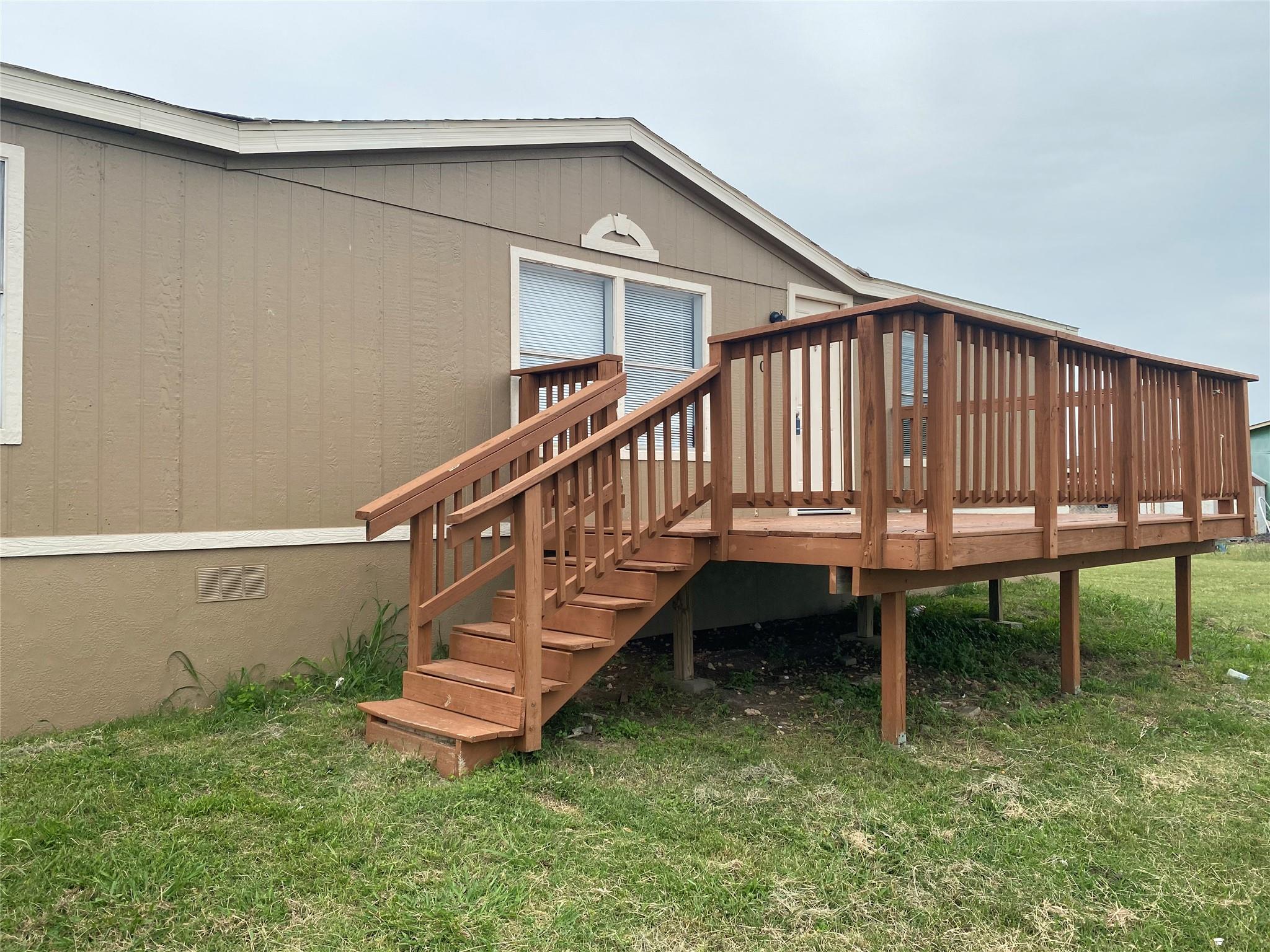An elevated wooden deck provides a spacious outdo