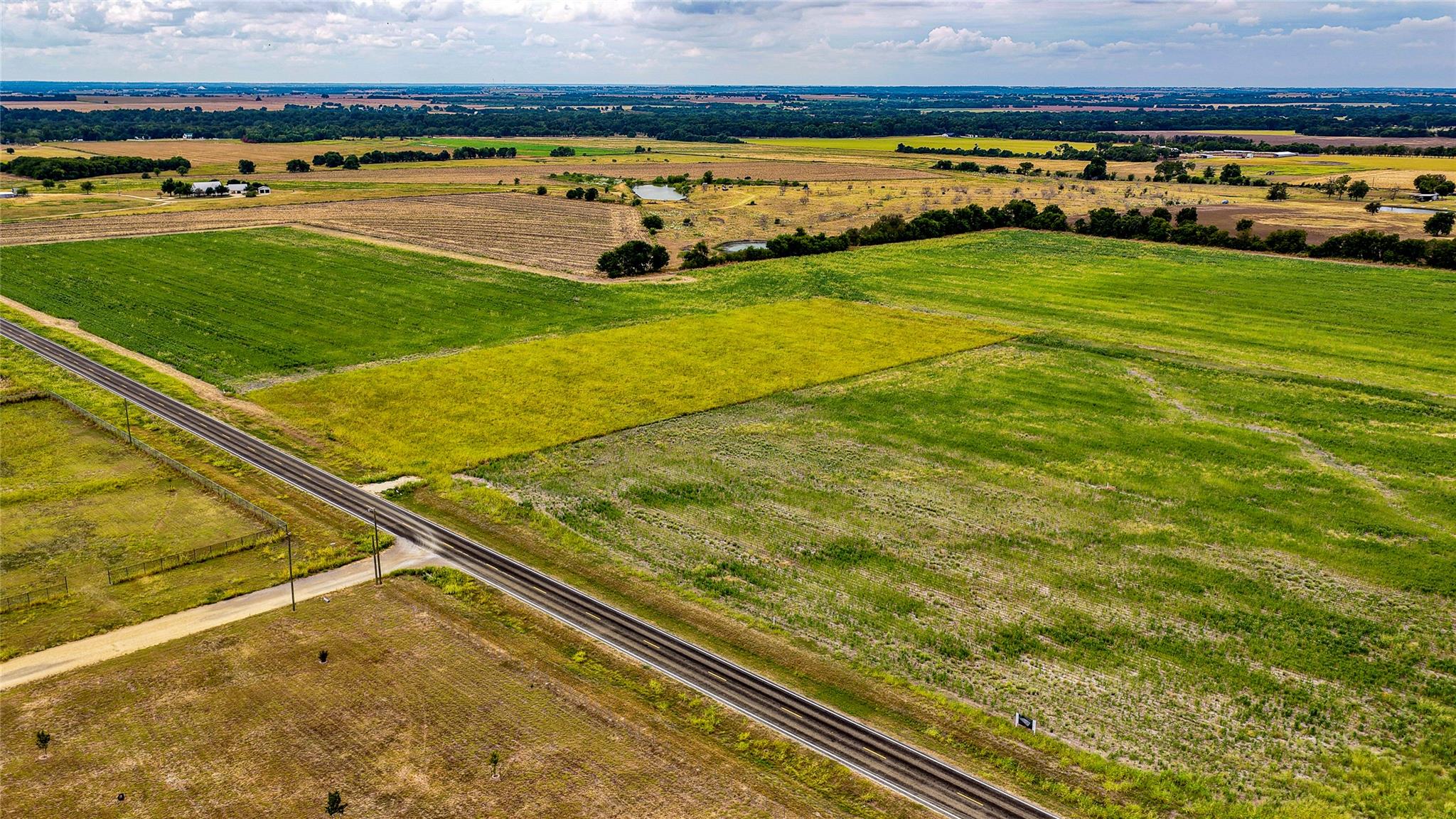 Vast green fields stretch toward the horizon unde