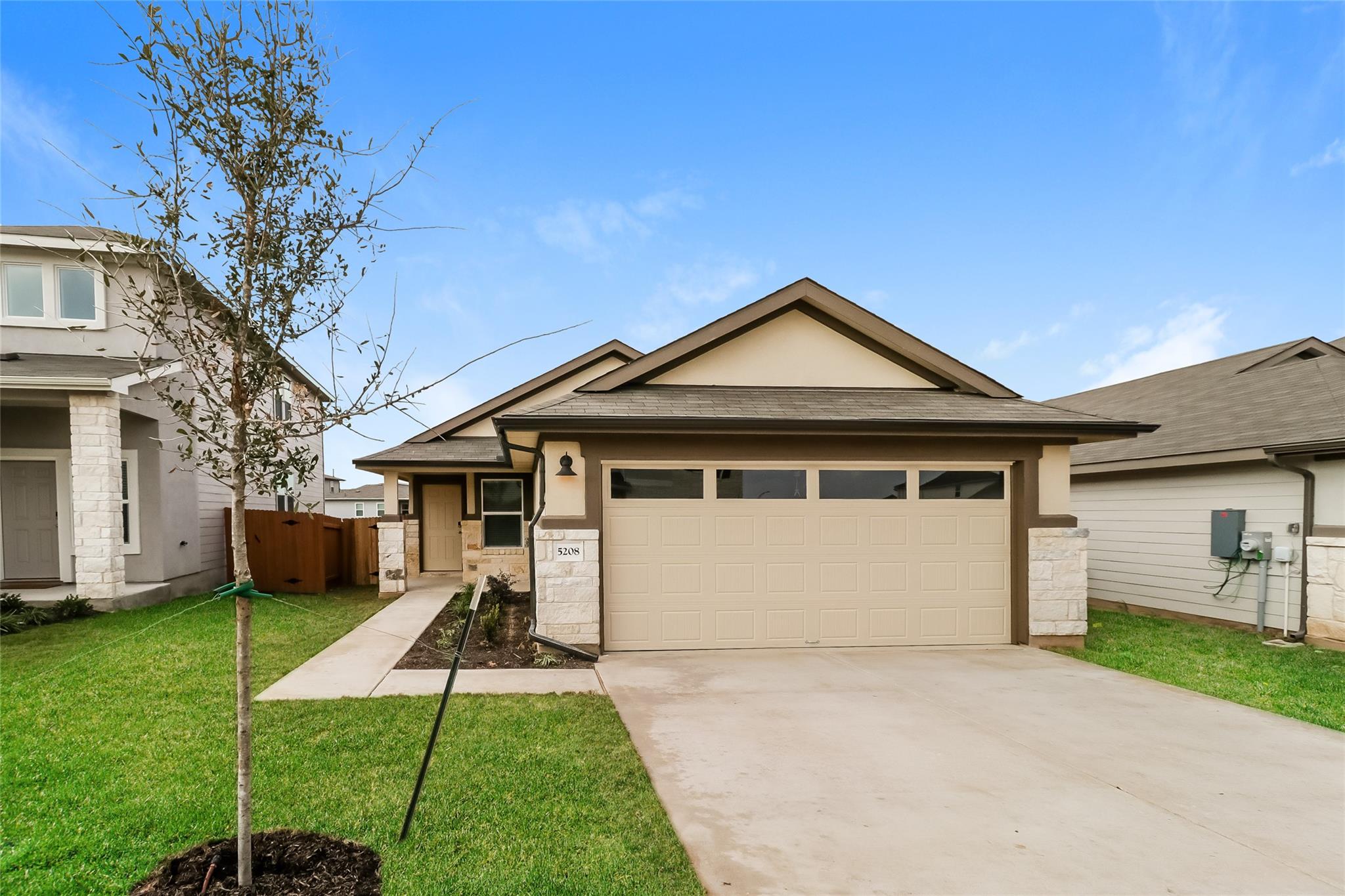 A concrete driveway leads to the two-car garage o