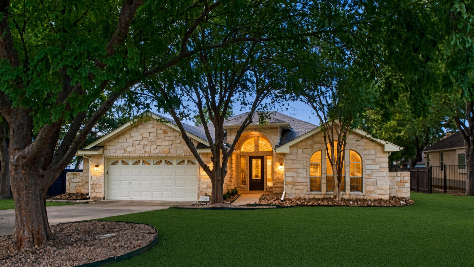 Mature trees shade a classic stone exterior with 