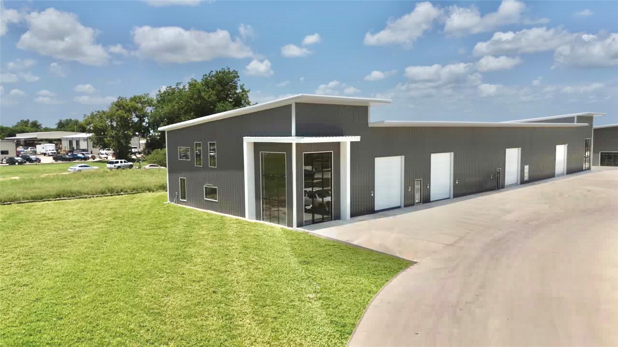 Modern metal siding and extensive concrete drivew