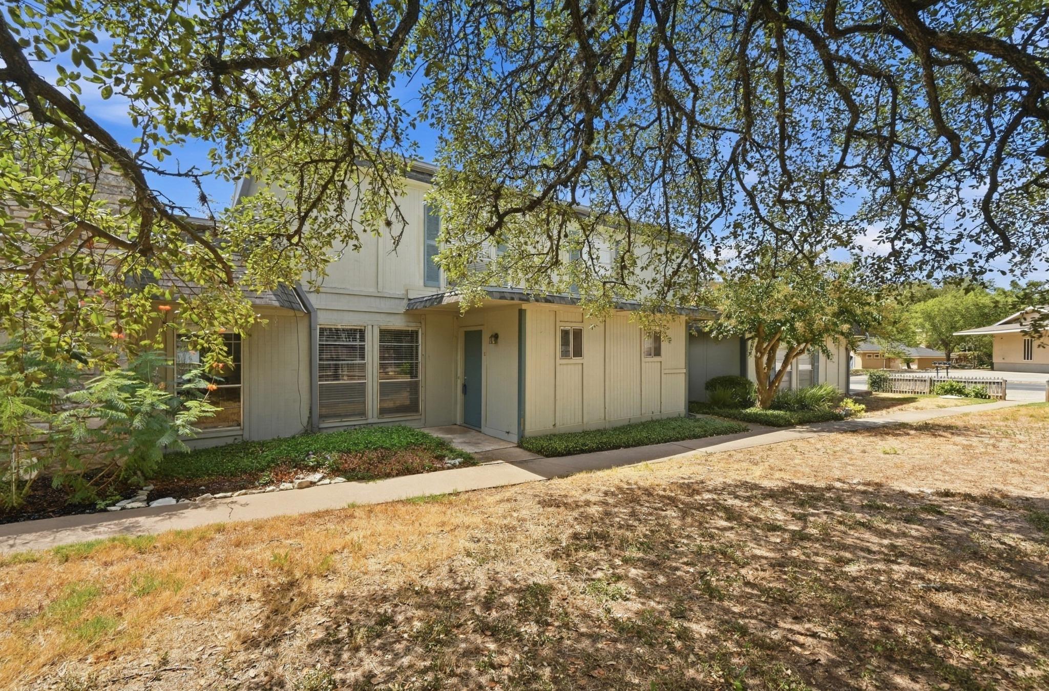 Mature shade trees frame the welcoming entrance p