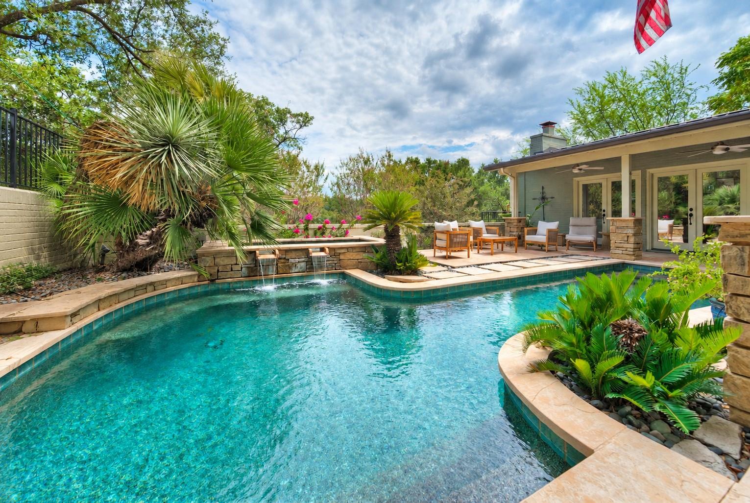 An inviting swimming pool features stone water sp